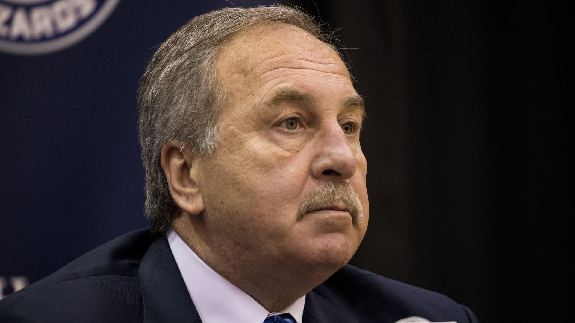 Ernie Grunfeld sitting at a podium