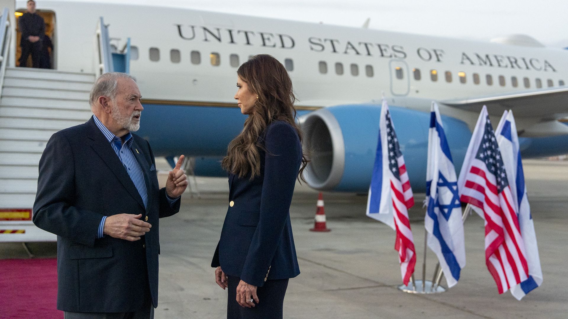 Homeland Security Secretary Kristi Noem speaks with Ambassador Mike Huckabee at Ben Gurion Airport in Tel Aviv, Israel. 