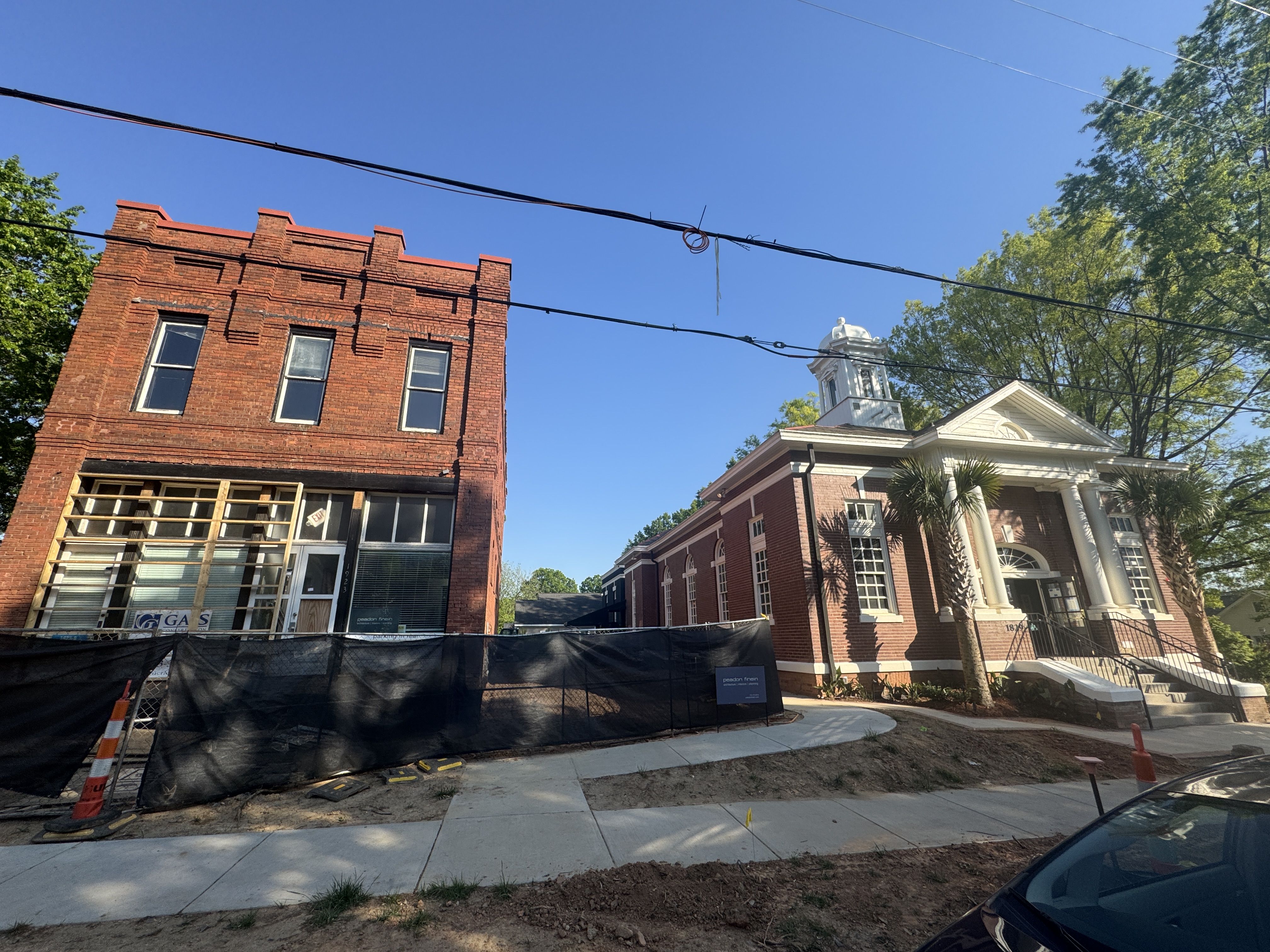 a brick building on the left and a church on the right