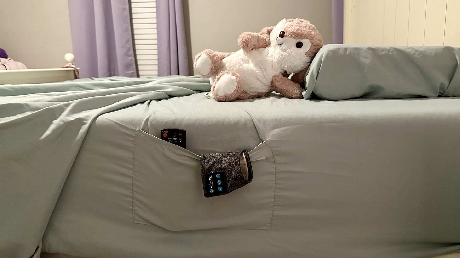 Sheets with pockets holding a remote and headband headphones