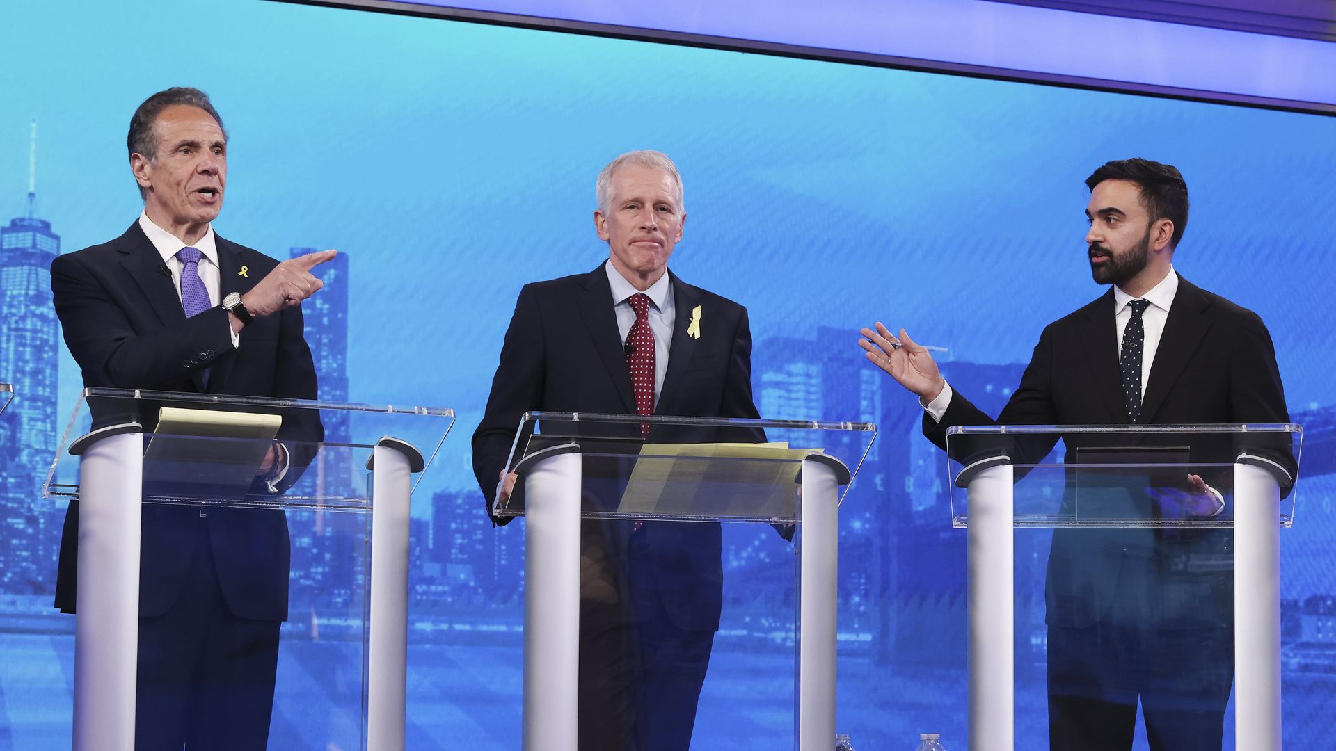 Andrew Cuomo, Whitney Tilson, and Zohran Mamdani speak at a debate.