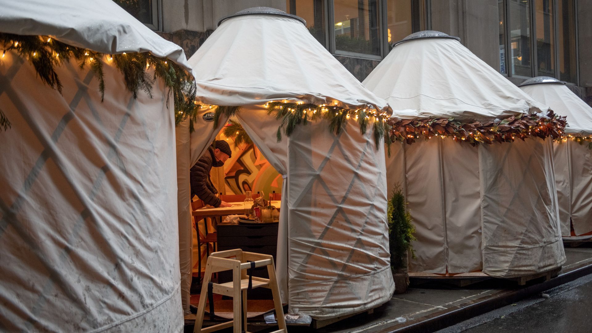 A server sanitizes an outdoor dining yurt in Manhattan.