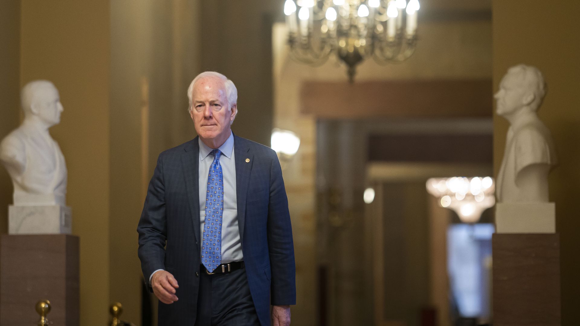 A photo of Sen. John Cornyn walking in a hallway