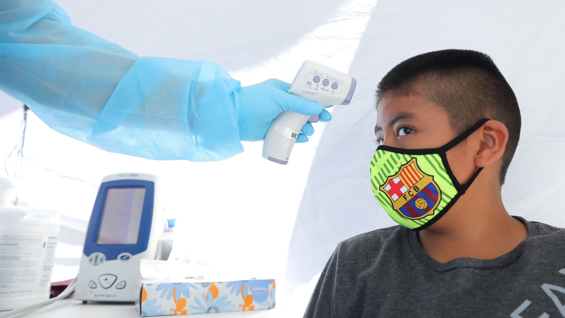 A boy has his temperature checked as he receives a free COVID-19 test in Los Angeles
