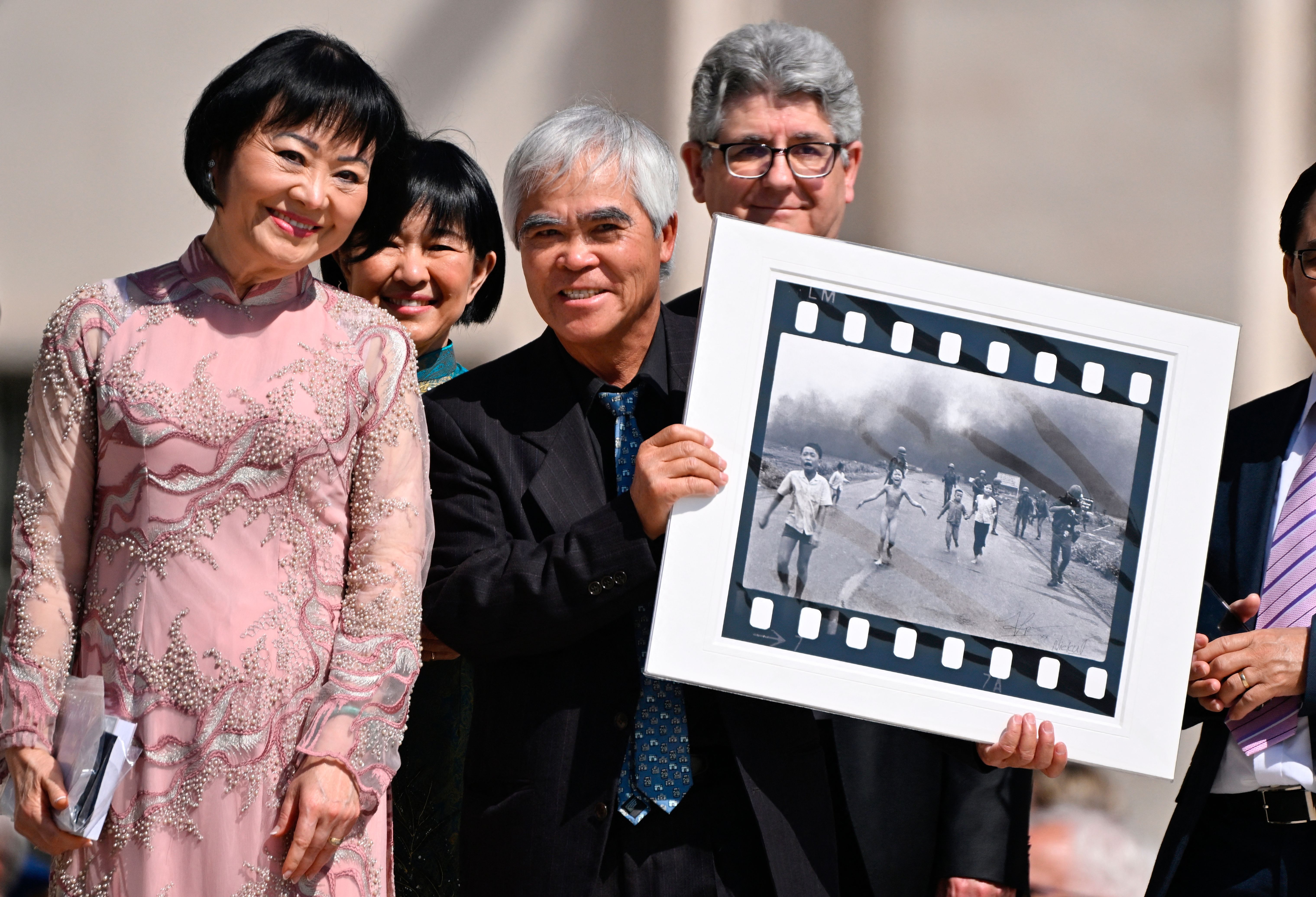 Ut holds up the "Napalm girl" photograph