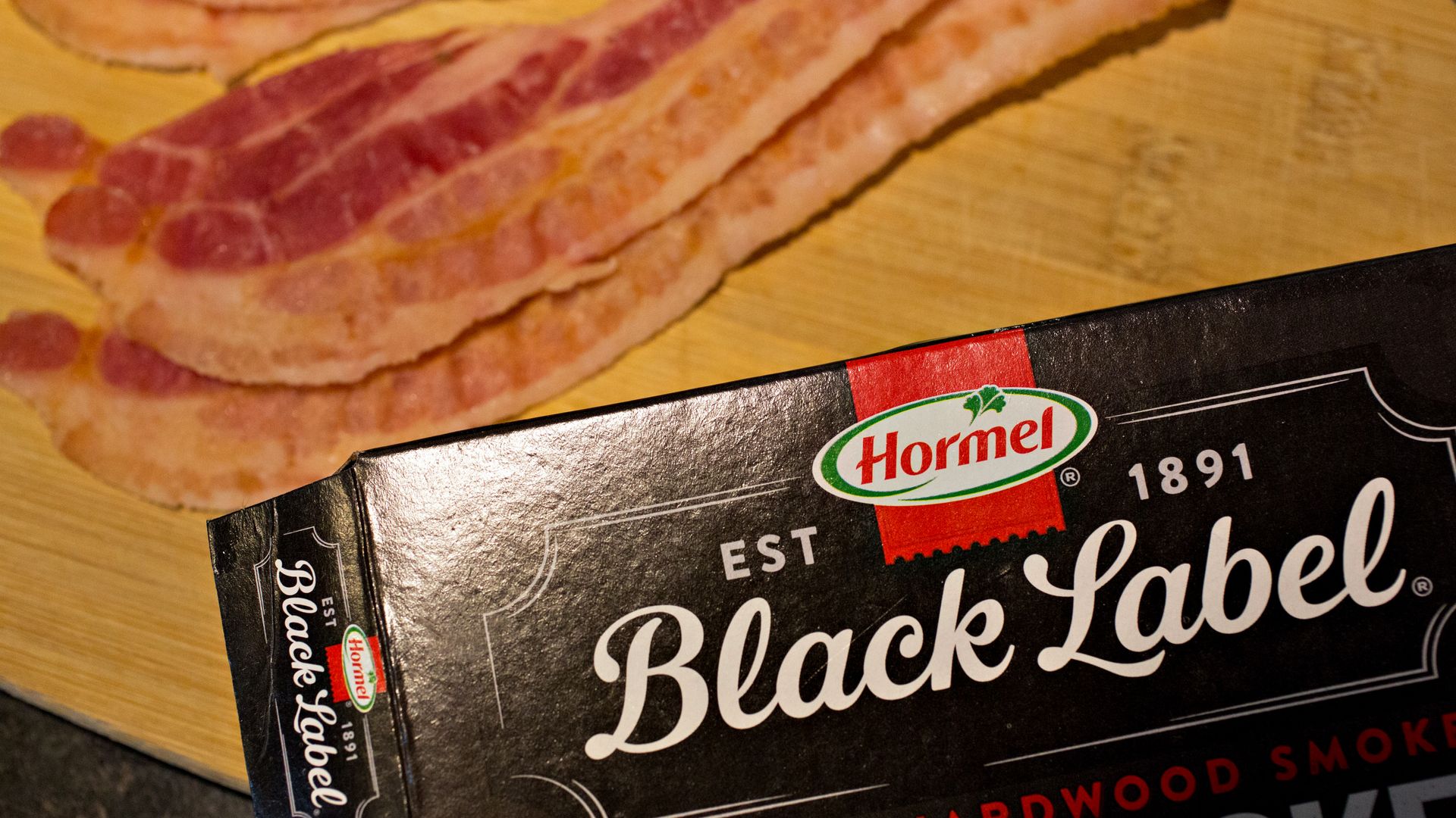 A package of Hormel black label bacon in front of a strip of bacon 