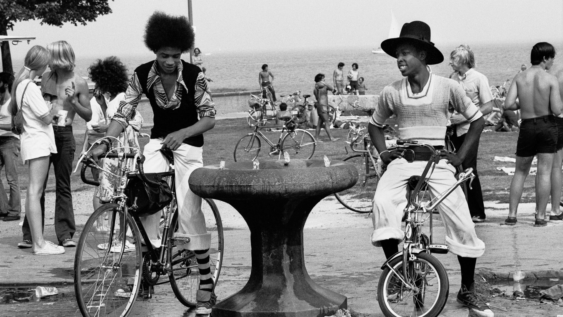 Photo of two teenagers on bicycles by a water fountain 