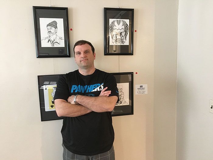 Brandon-Padgett-with-some-of-his-artwork