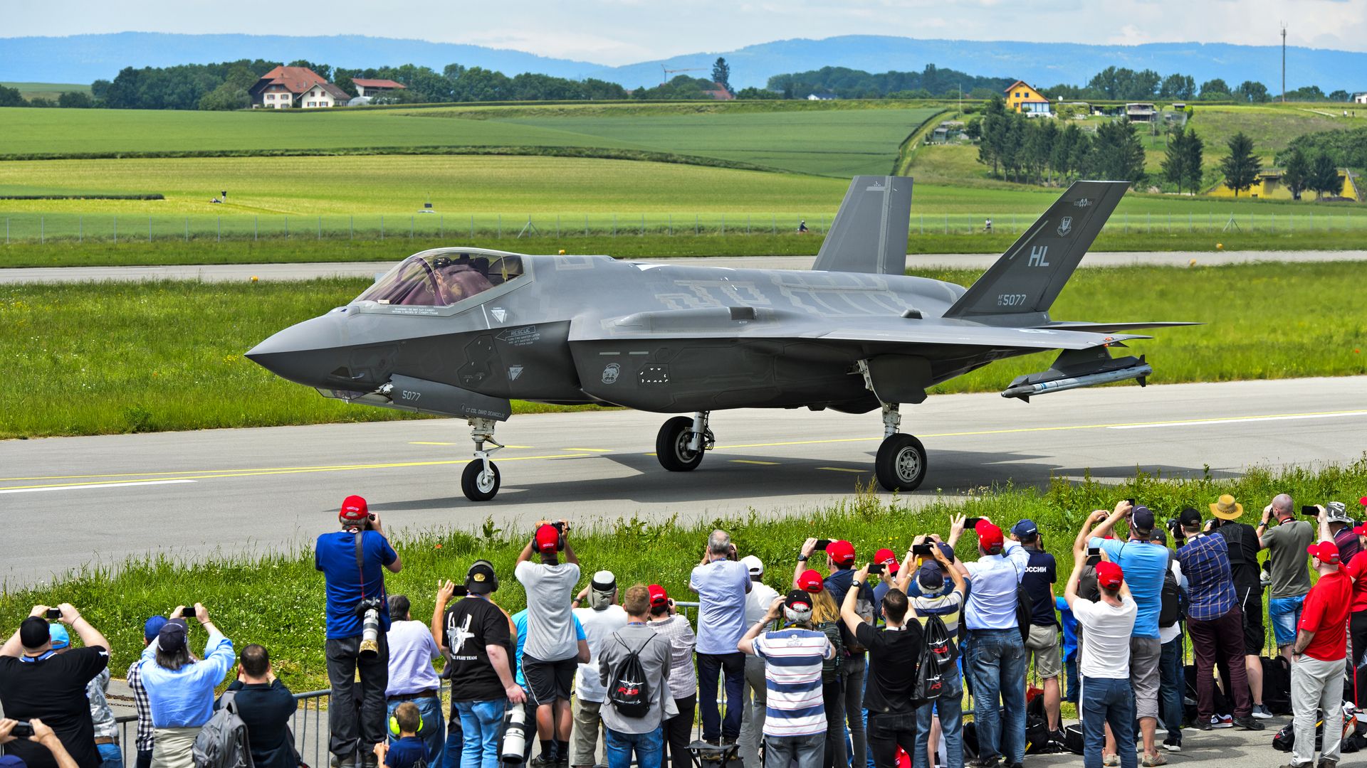 An F-35 on a runway in Switzerland with people looking on.