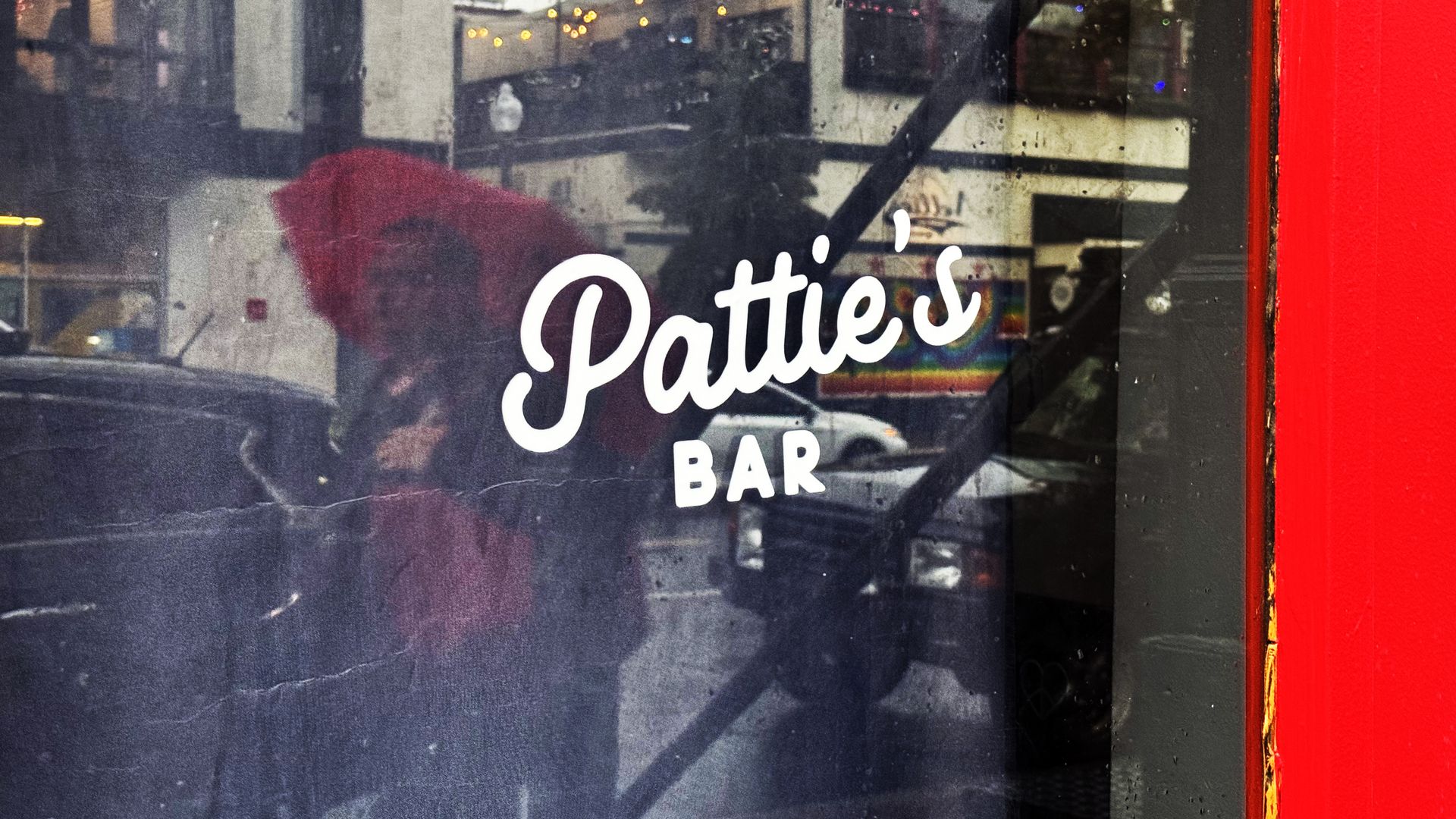 A photo of a glass window with the words "Pattie's Bar."