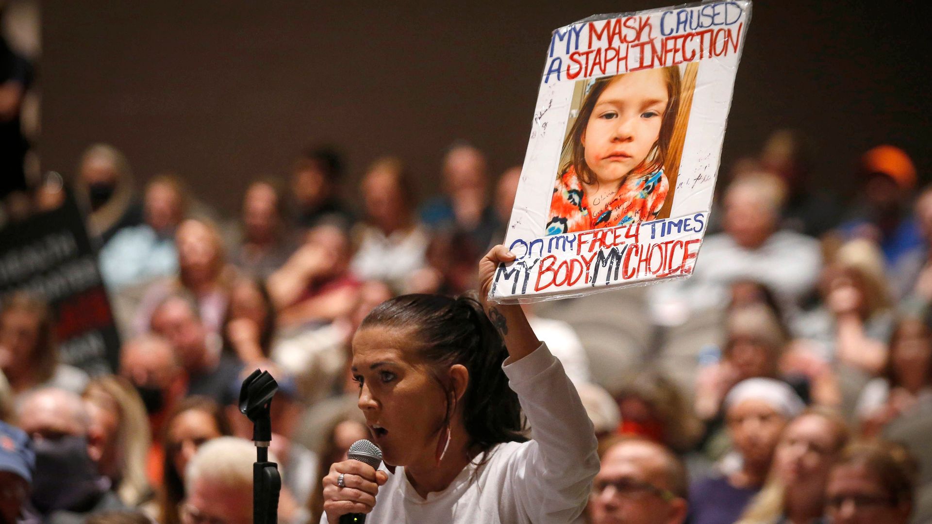 Kimberly Reicks holds up a sign of her daughter