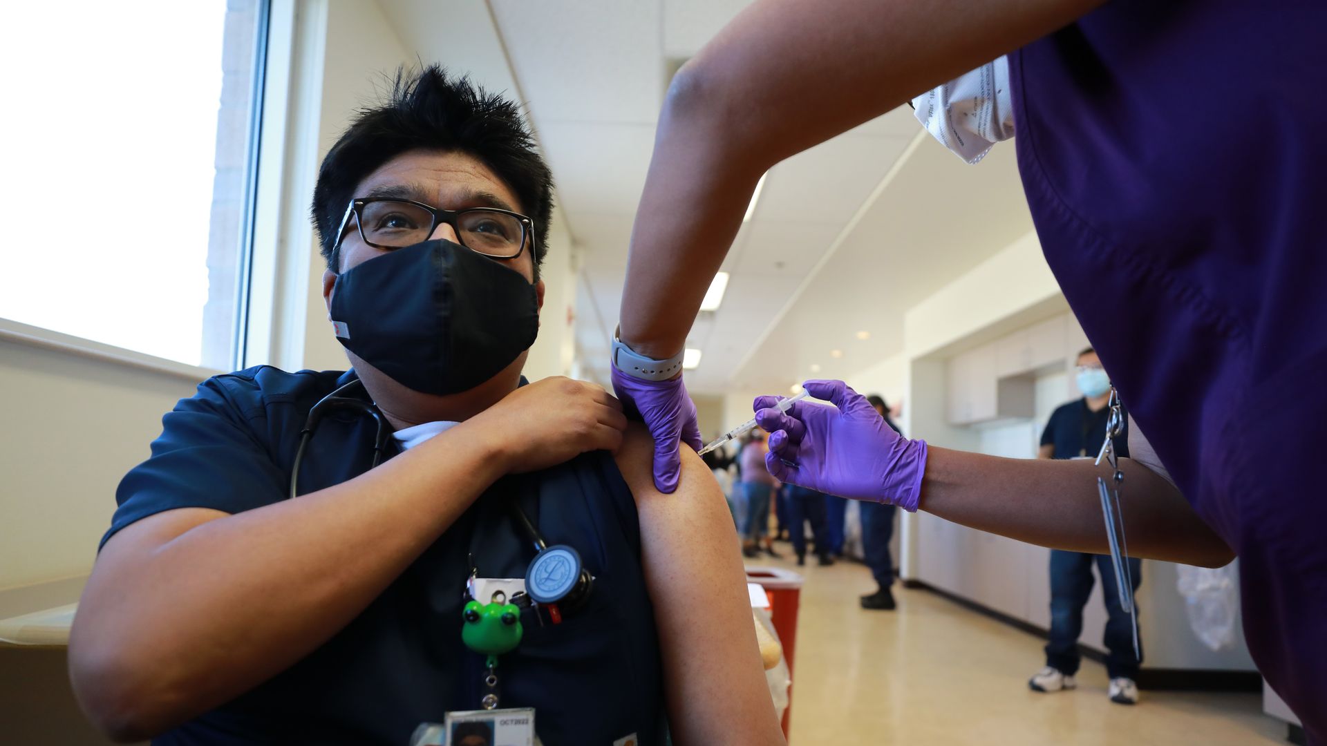 Photo of a masked medical worker getting the COVID vaccine shot