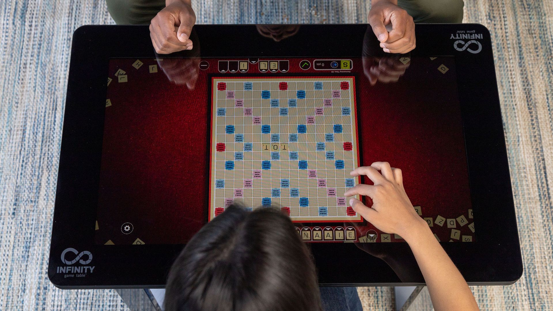 A couple plays Scrabble on the Infinity Game Table. 