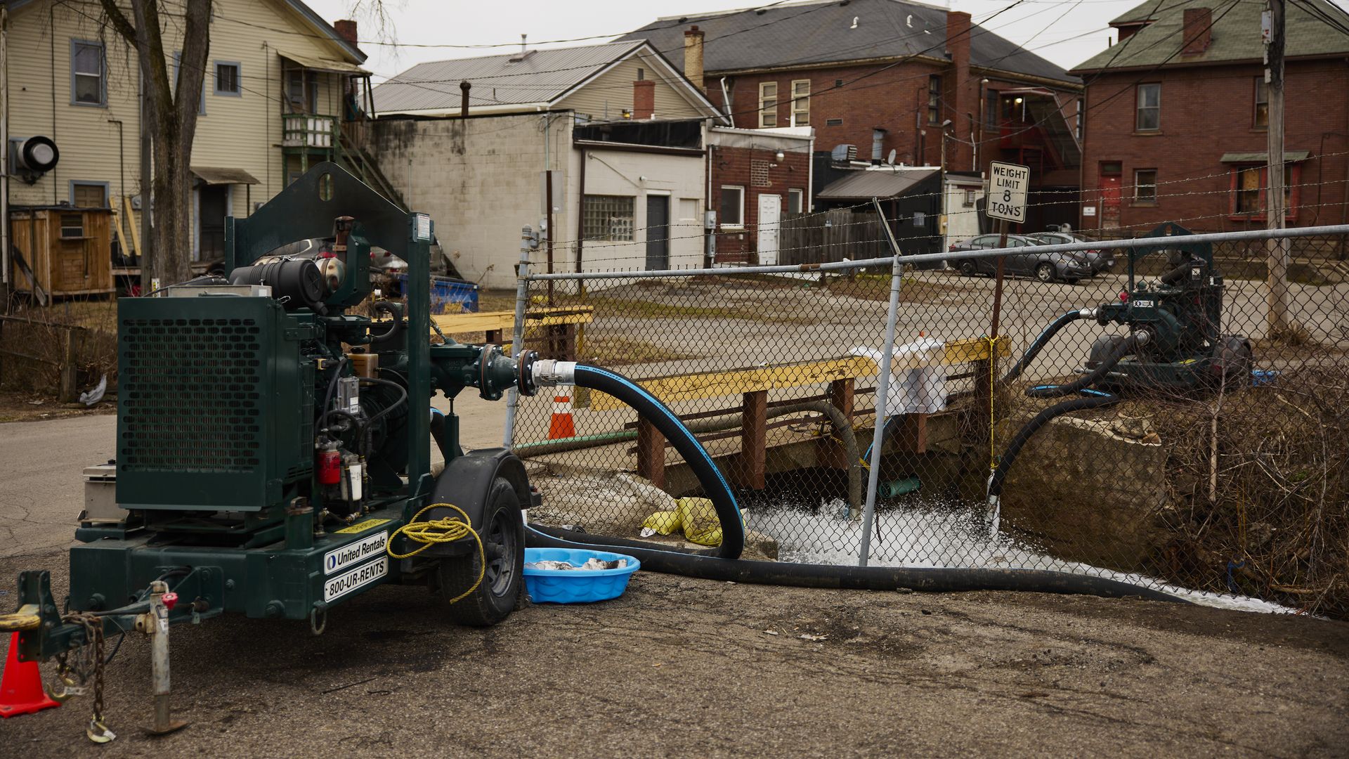Photo of water being pumped into a creek running under a road