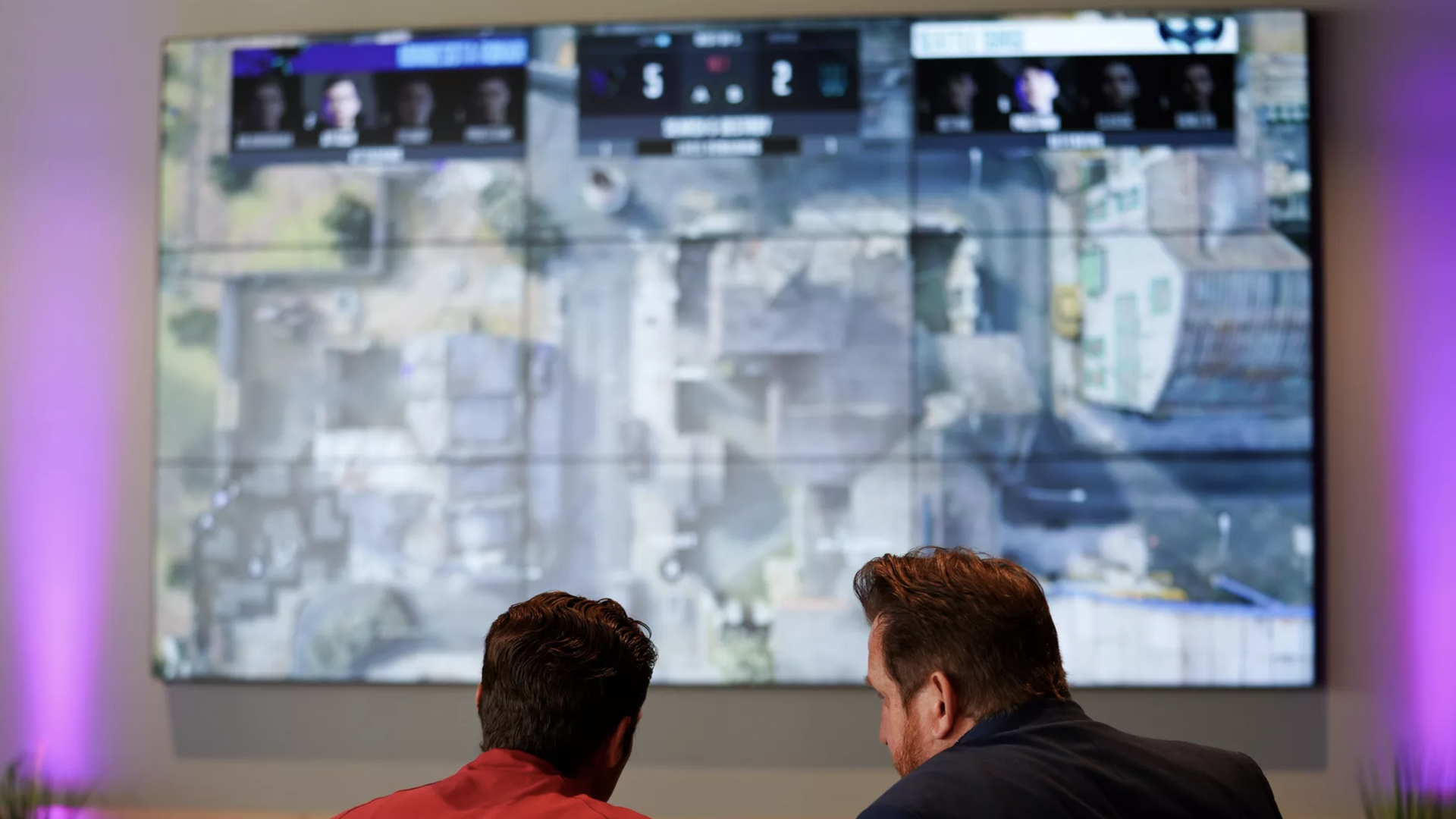 Photograph of two people looking at a big-screen projection of a Call of Duty level