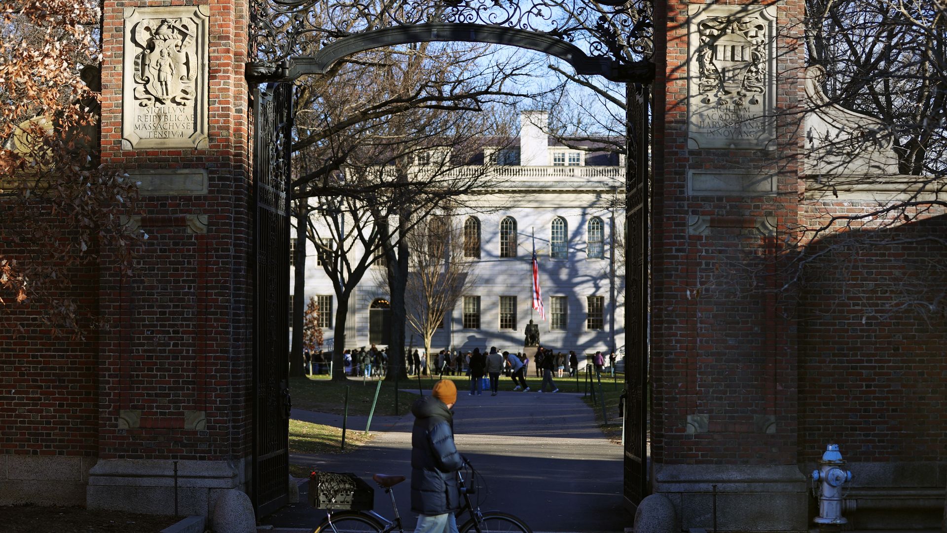 The entrance to Harvard Yard. Harvard University as a man passes by on a bike.
