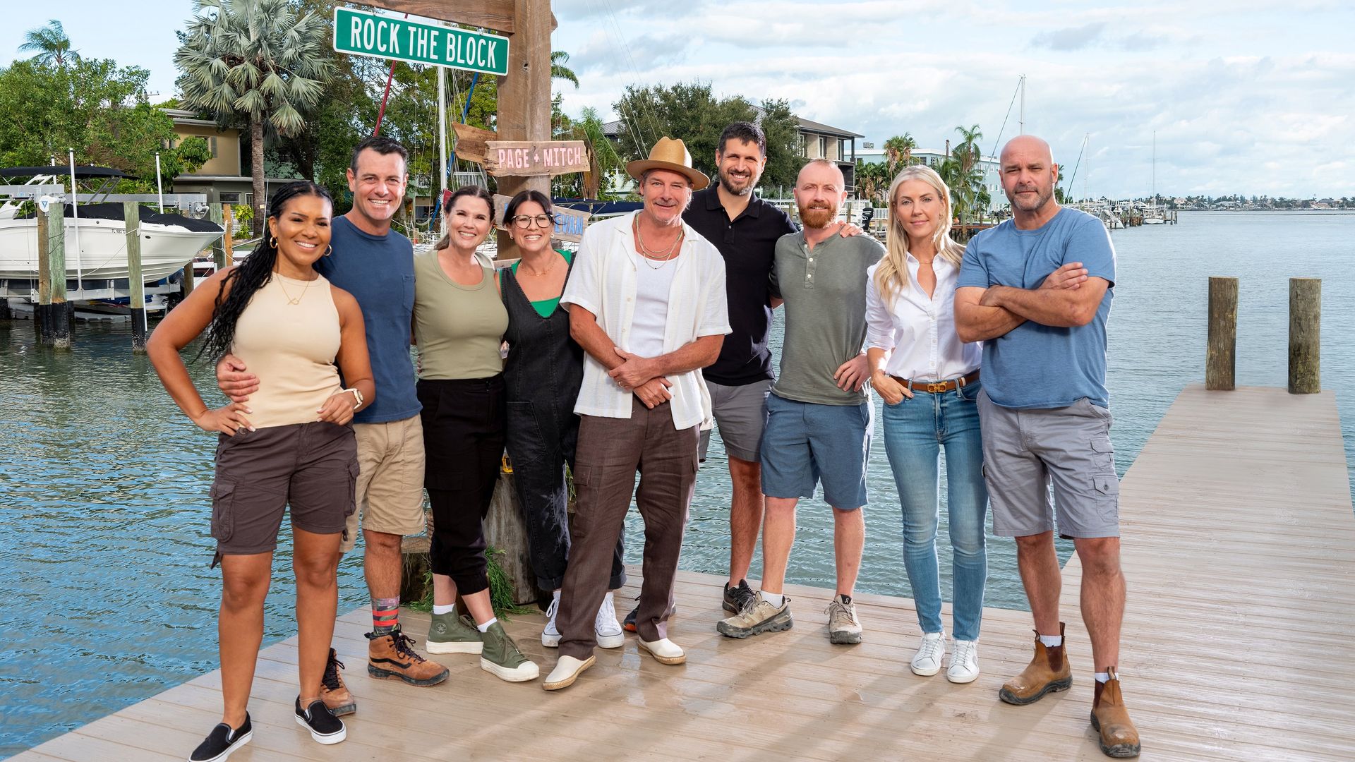 The cast of Rock the Block standing on a dock below a street sign reading "rock the dock"