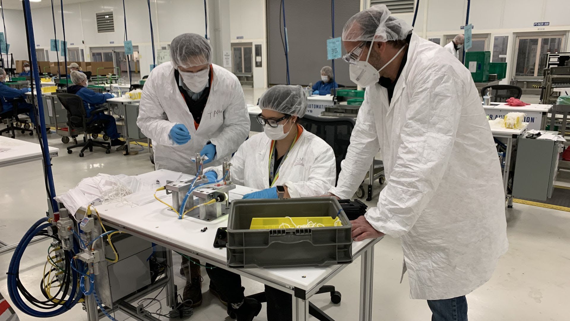 GM workers collaborate as we all will some day: wearing masks.