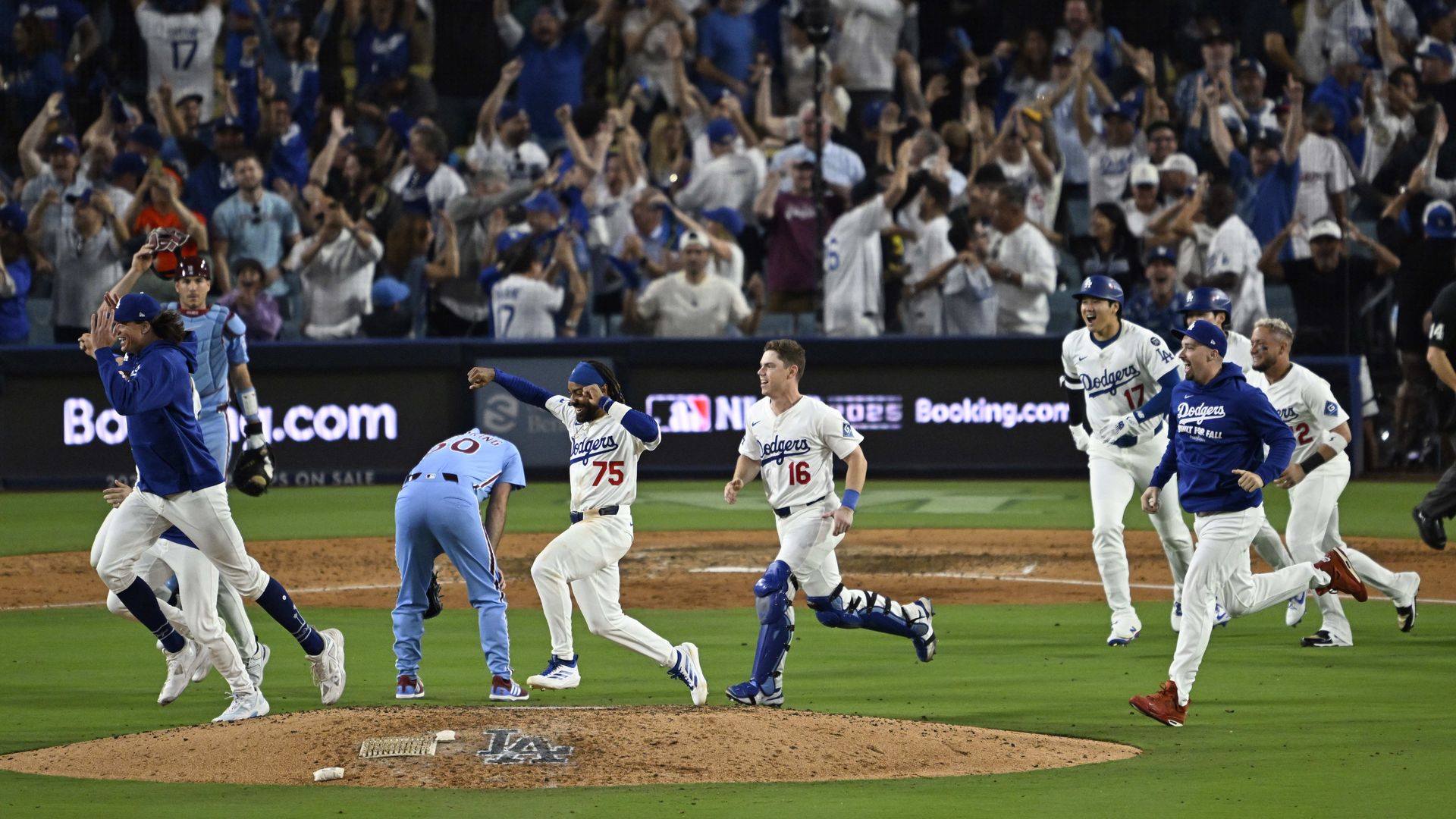 The Los Angeles Dodgers celebrate as they run past relief pitcher Orion Kerkering after defeating the Phillies 2-1 in the eleventh inning of Game 4 of last season's NLDS.