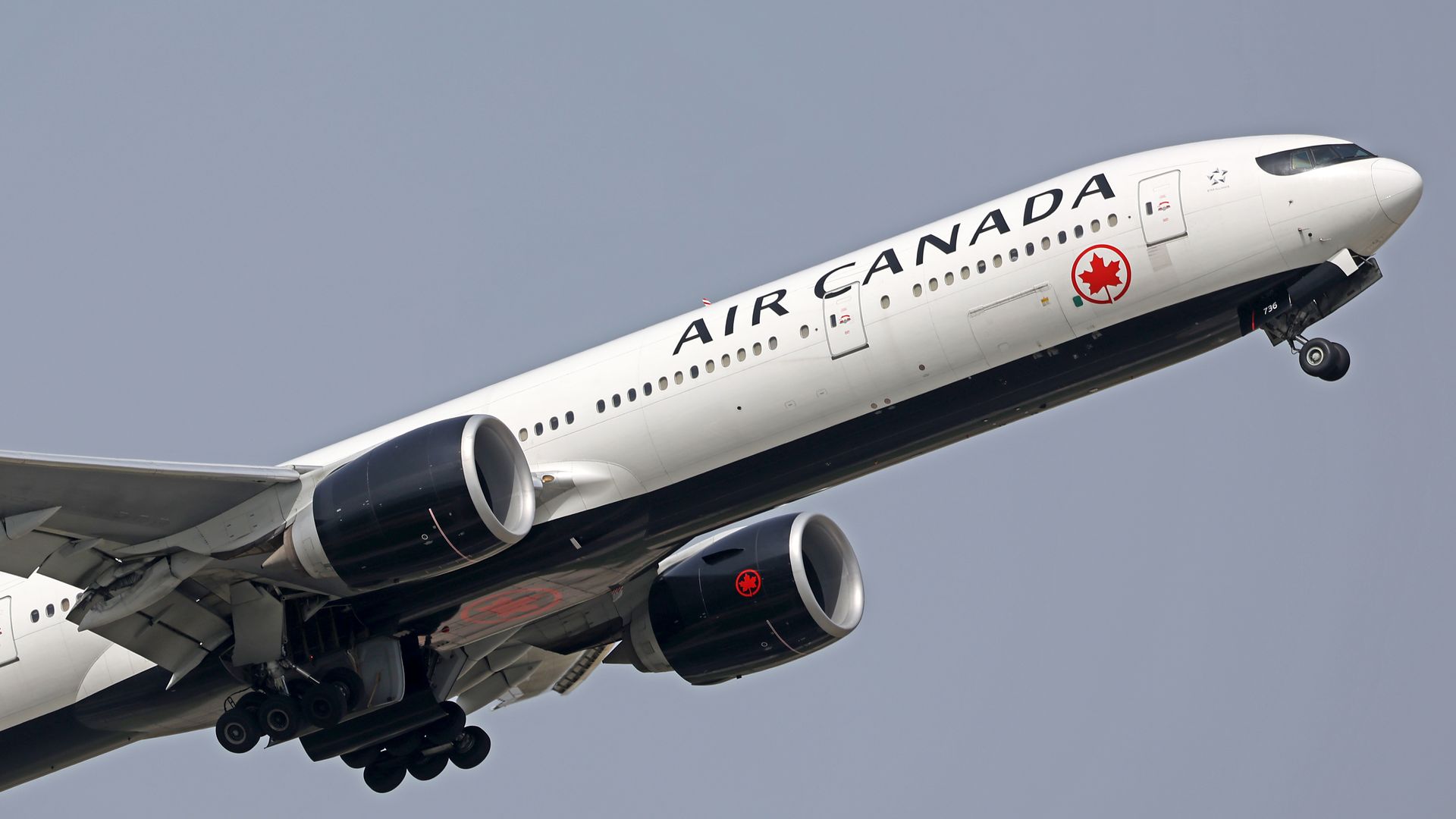 White Air Canada airplane taking off over overcast sky