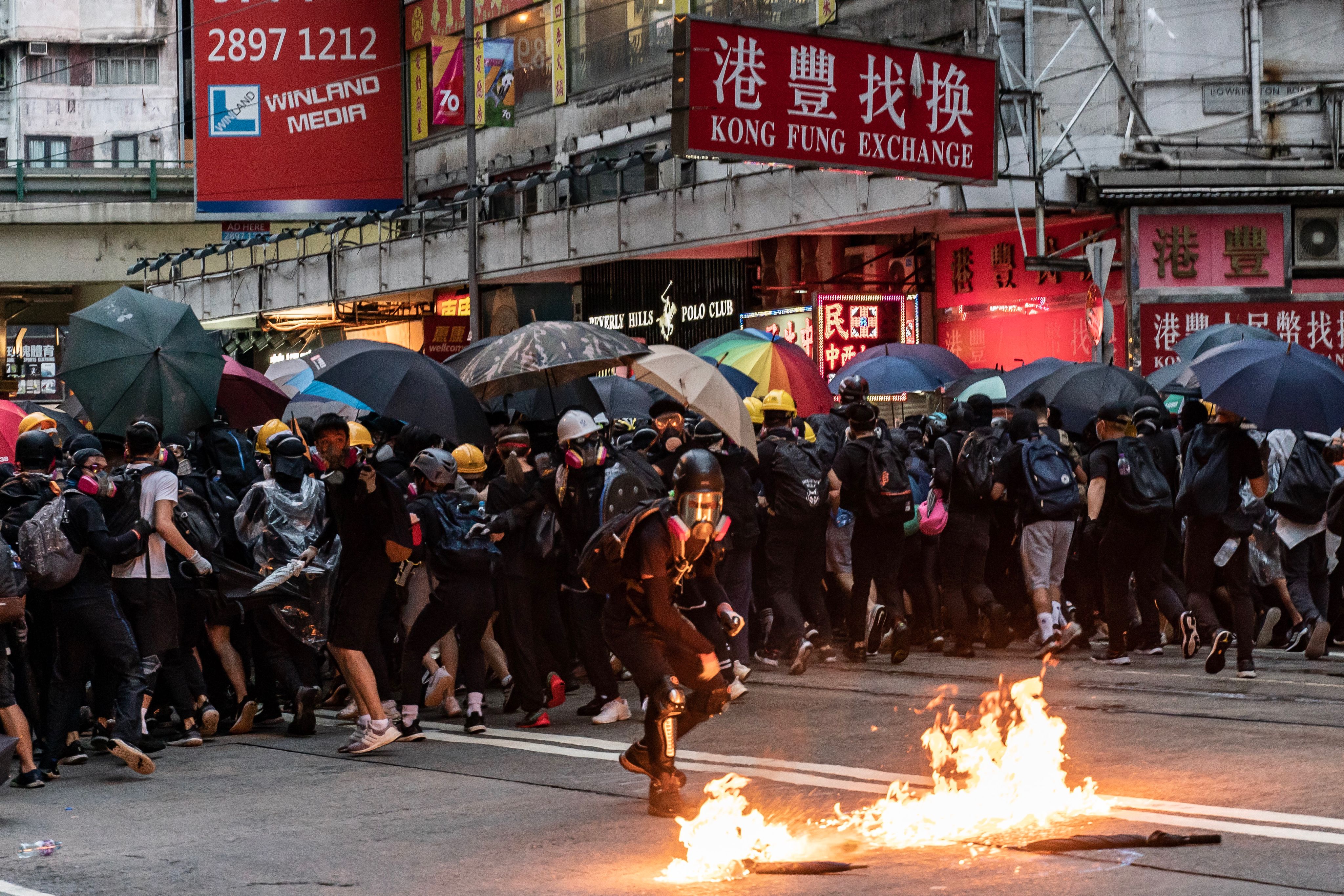 A pro-democracy protester throws a Molotov cocktail in Wan Chai district