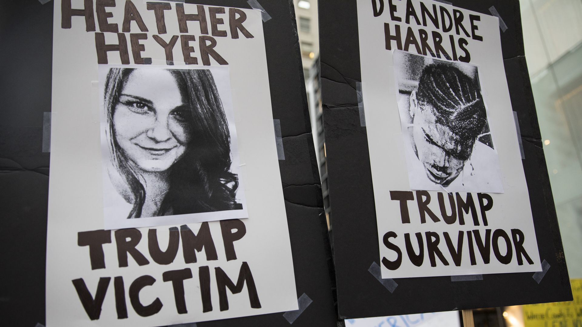 protest signs with images of Heather Heyer and Deandre Harris