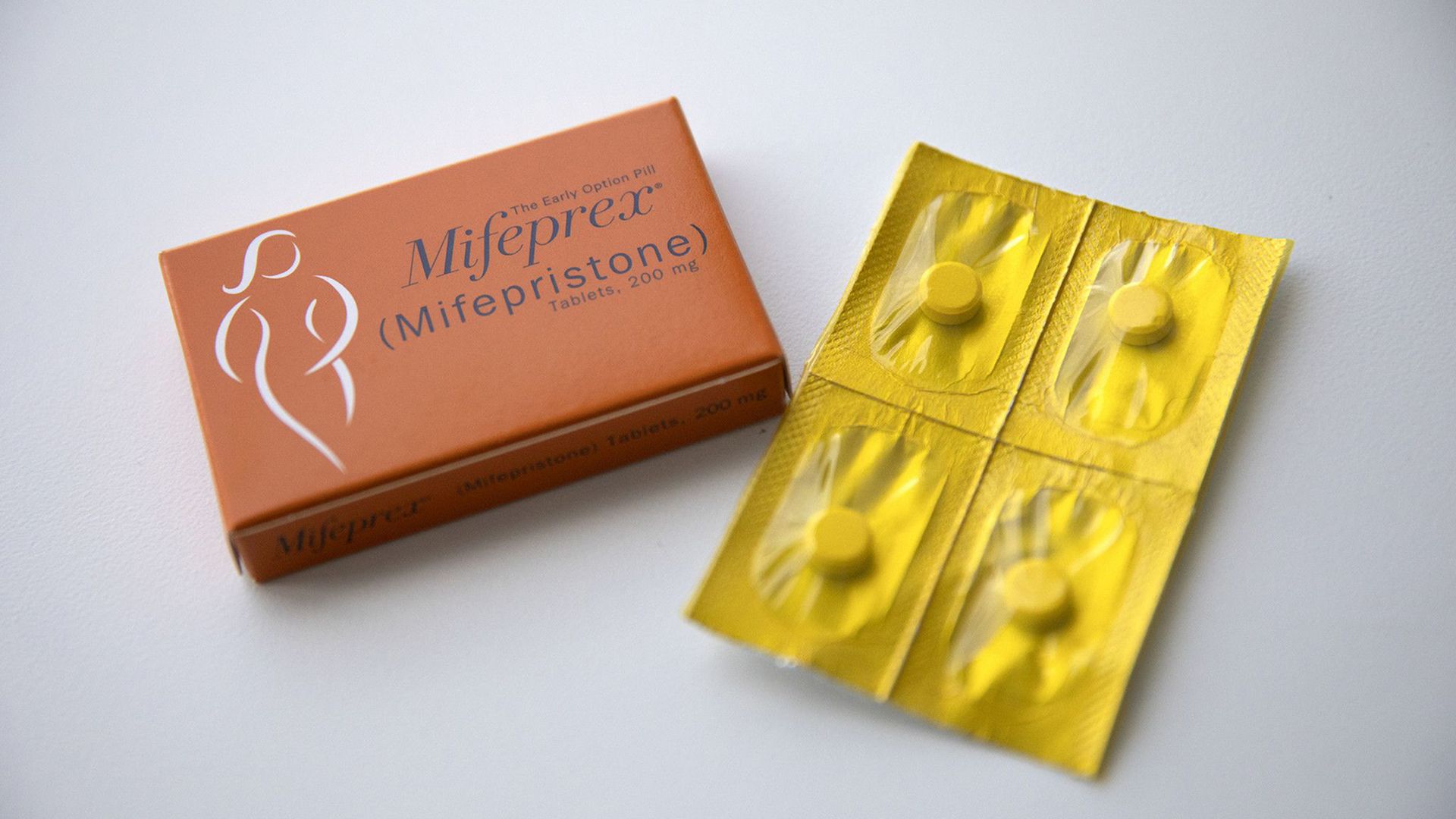 Mifepristone in an orange box and yellow pill blisters of misoprostol