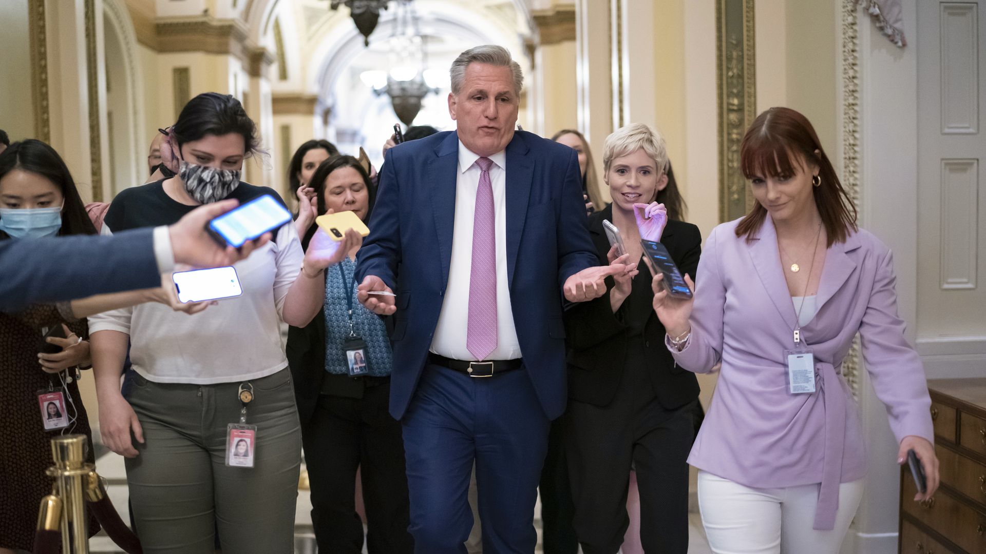 Kevin McCarthy walking in a hallway surrounded by reporters 