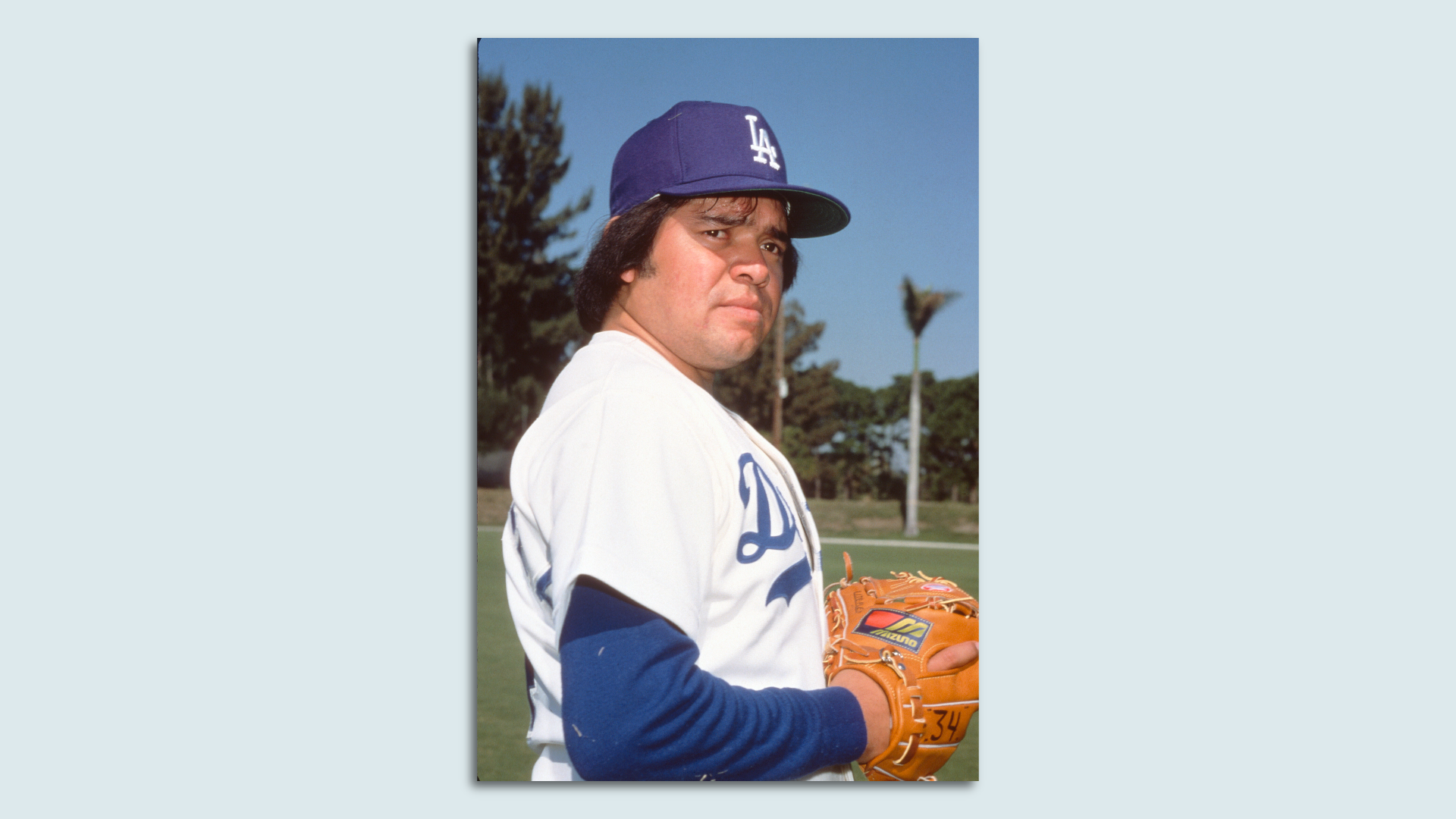 Fernando Valenzuela looks to the side while wearing a baseball glove.