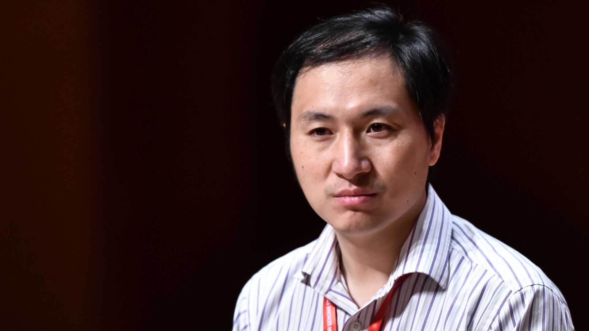 In this image, Chinese scientist He Jiankui sits and listens to someone speaking