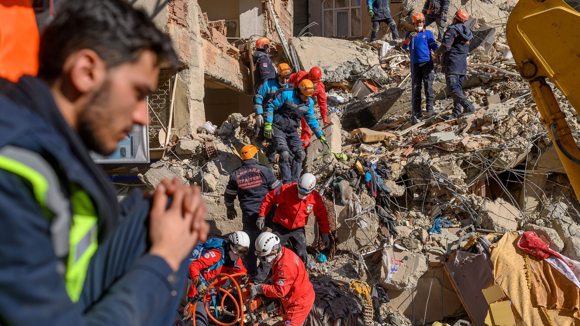 Rescue workers work amid the rubble of a building after an earthquake in Elazig, eastern Turkey