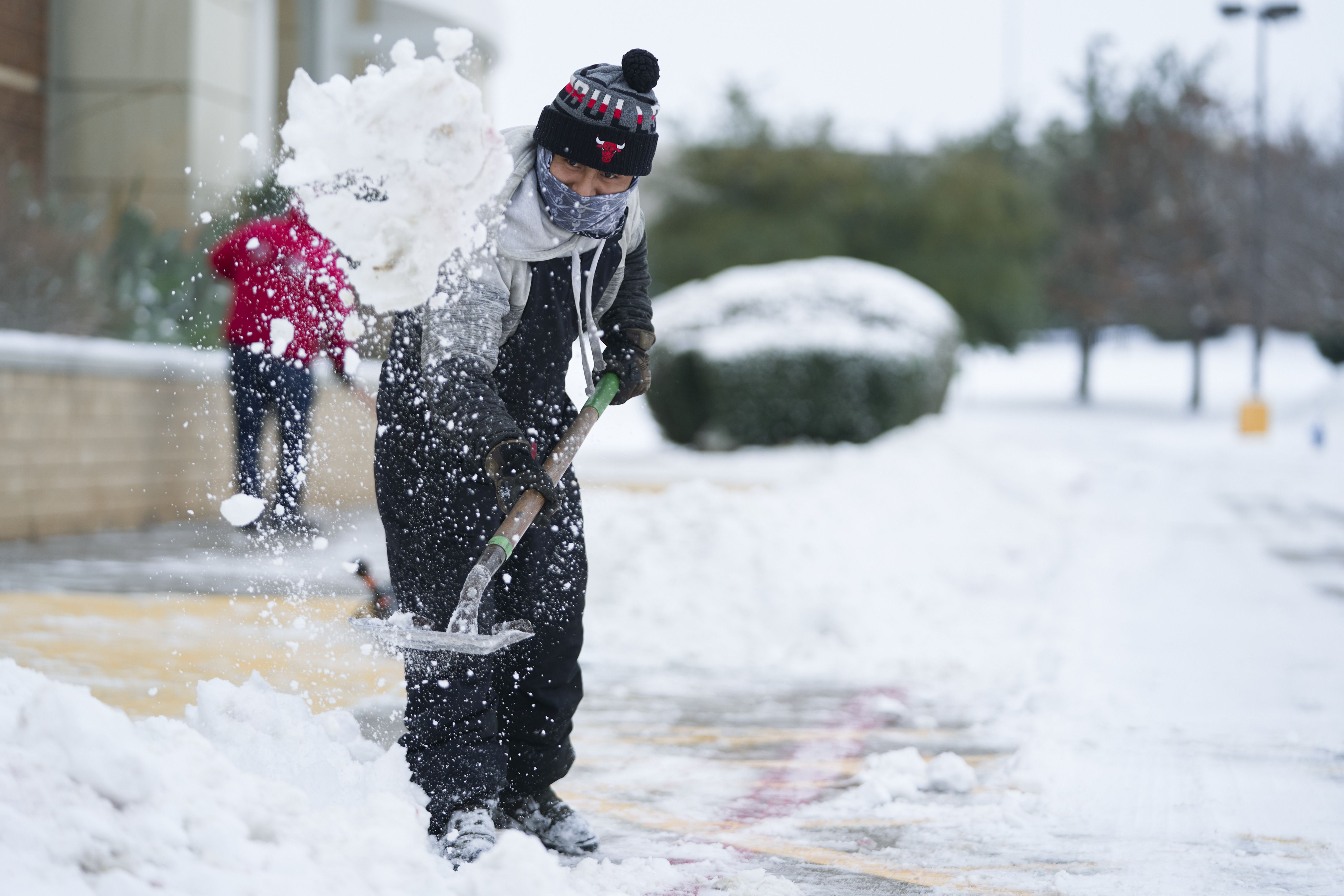 A person shoveling off a sidewalk in McKinney, Texas, in February 2021.