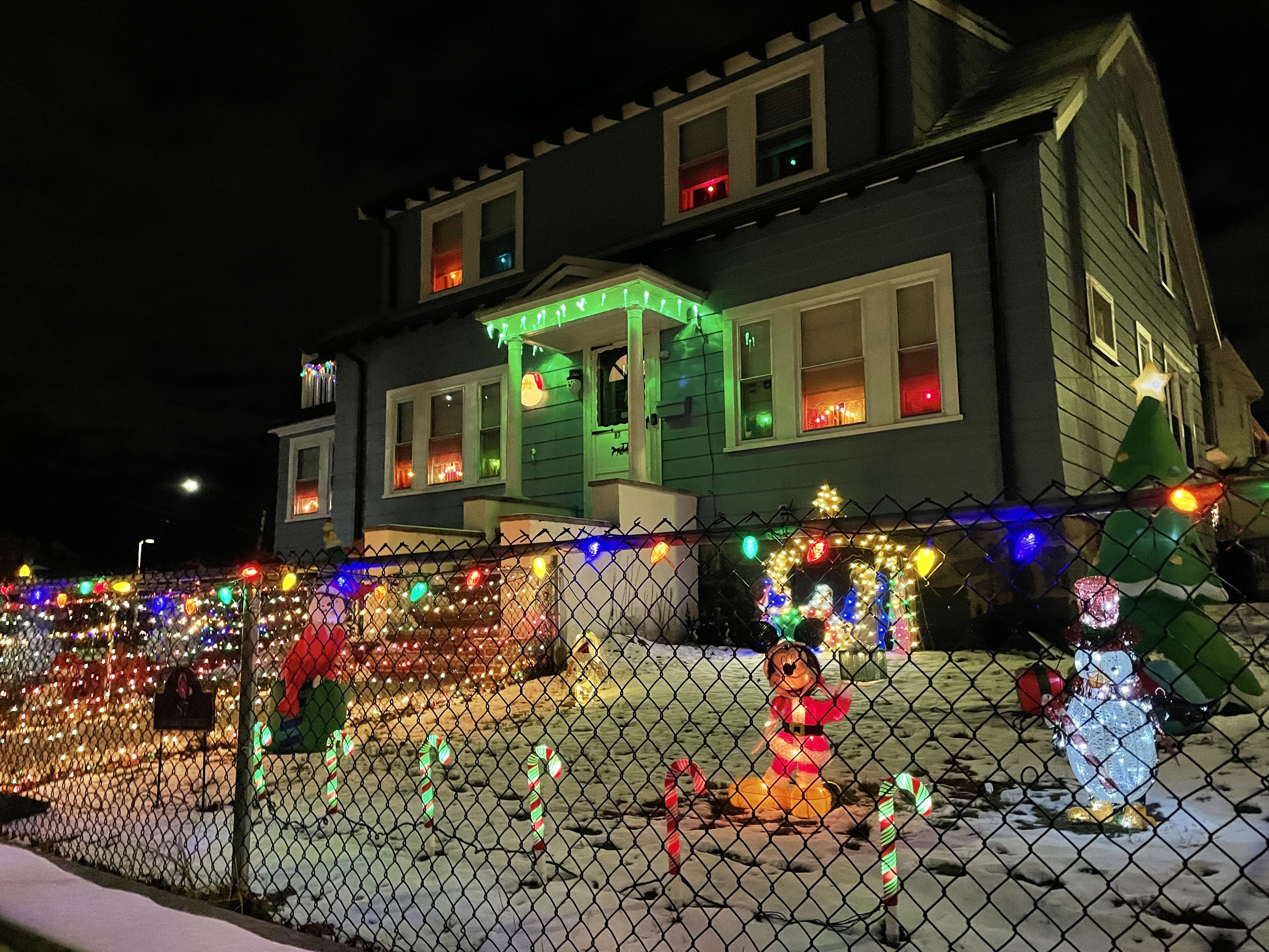 Candy canes in several colors, a Mickey Mouse figurine and blow-up Christmas tree adorn the front lawn of this Dorchester home. 