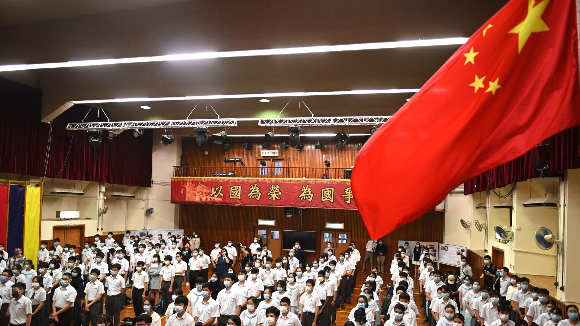 Students standing under China flag