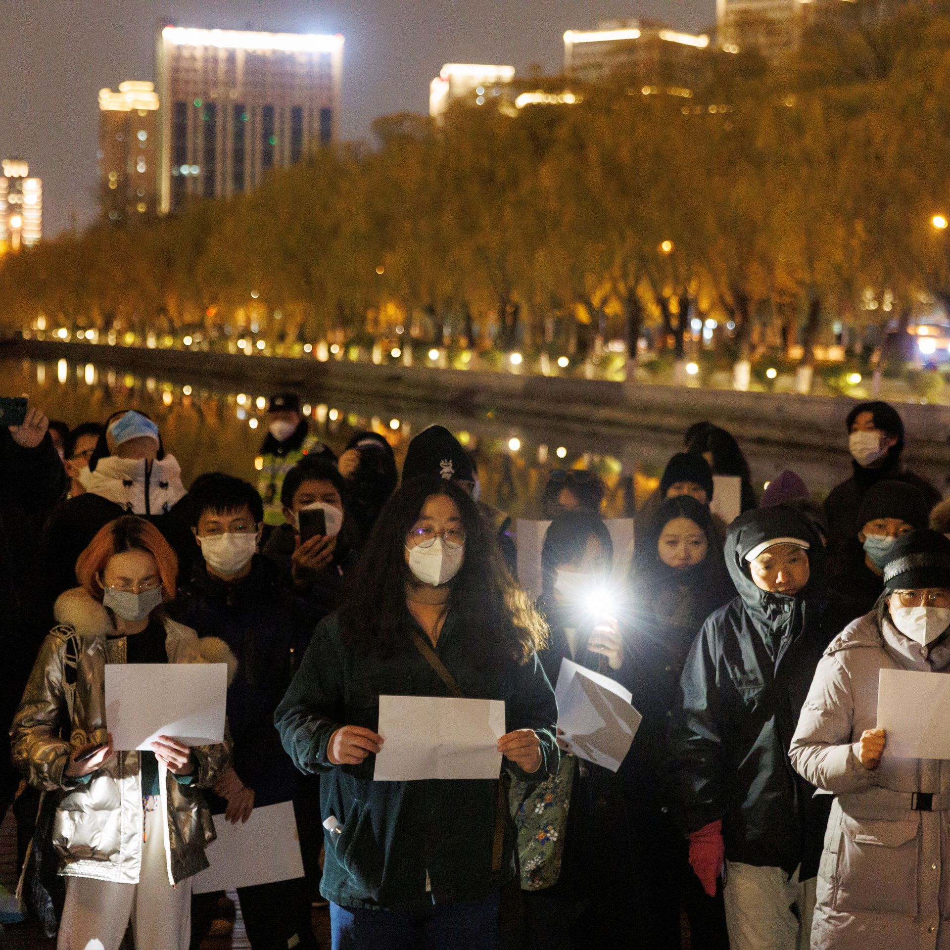 People hold white sheets of paper in Beijing yesterday to protest COVID restrictions.