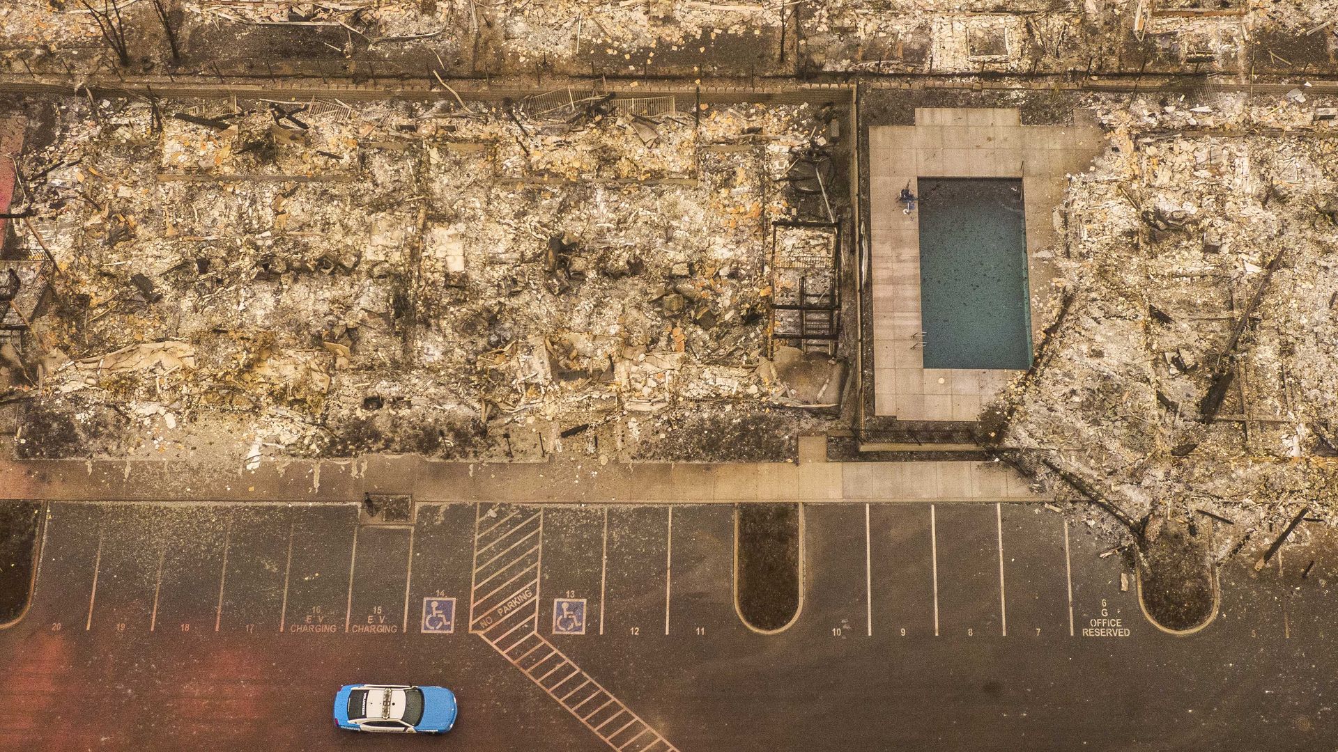 In this aerial view from a drone, a police patrol car drives by apartment homes destroyed by wildfire on September 12, 2020 in Talent, Oregon. 