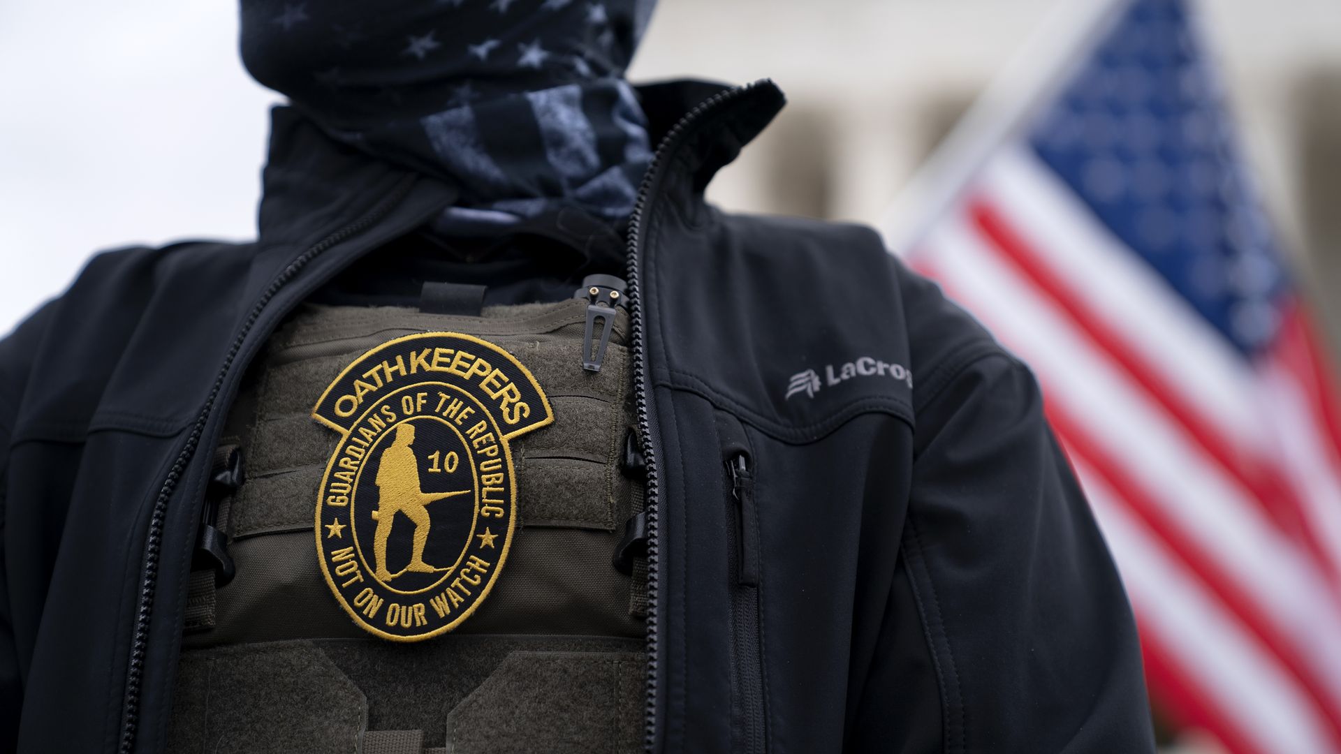 Photo of a person in tactical gear with an Oath Keepers badge