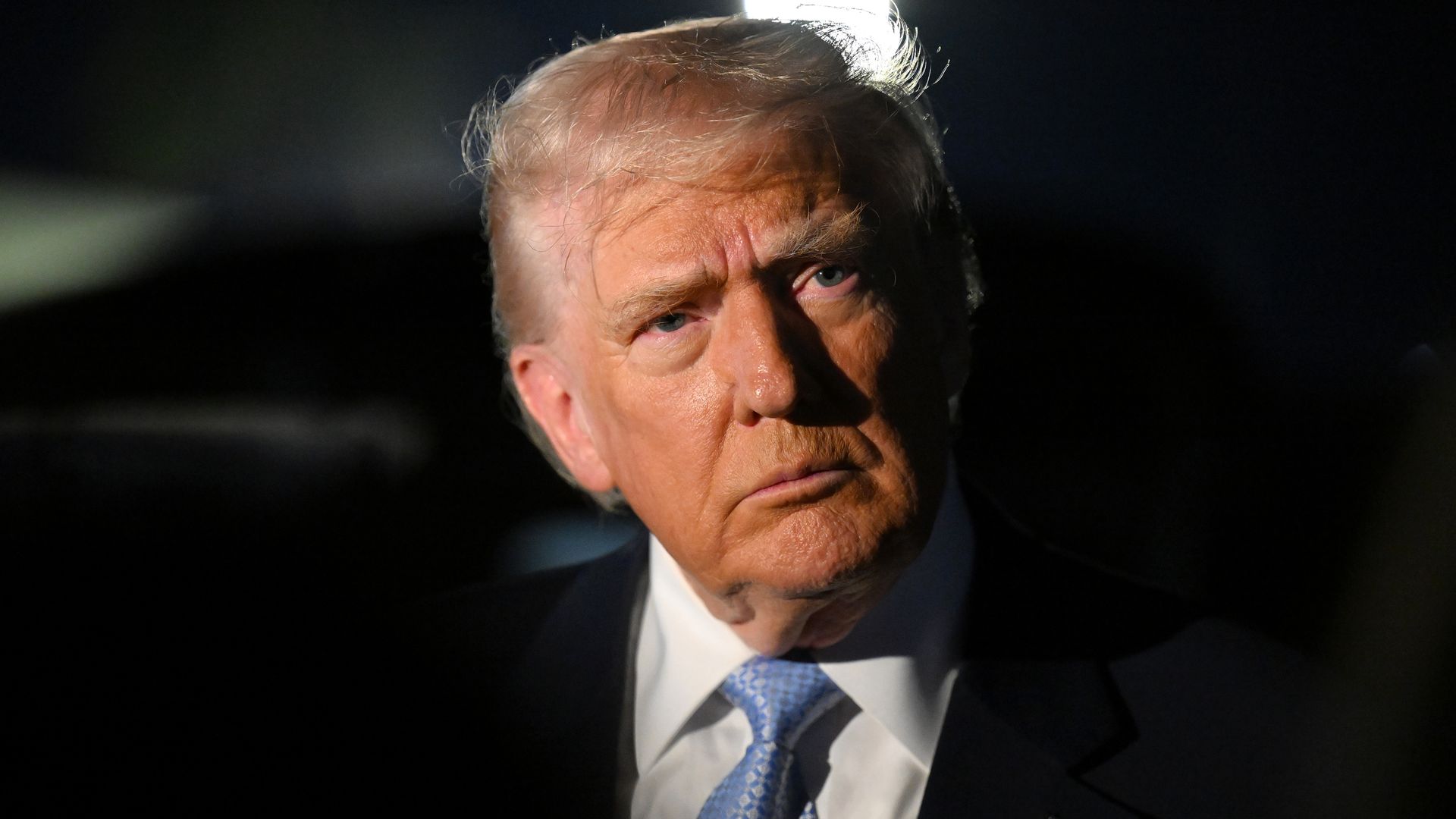 President Donald Trump talks to reporters near Air Force One at Palm Beach International Airport in West Palm Beach, Florida.