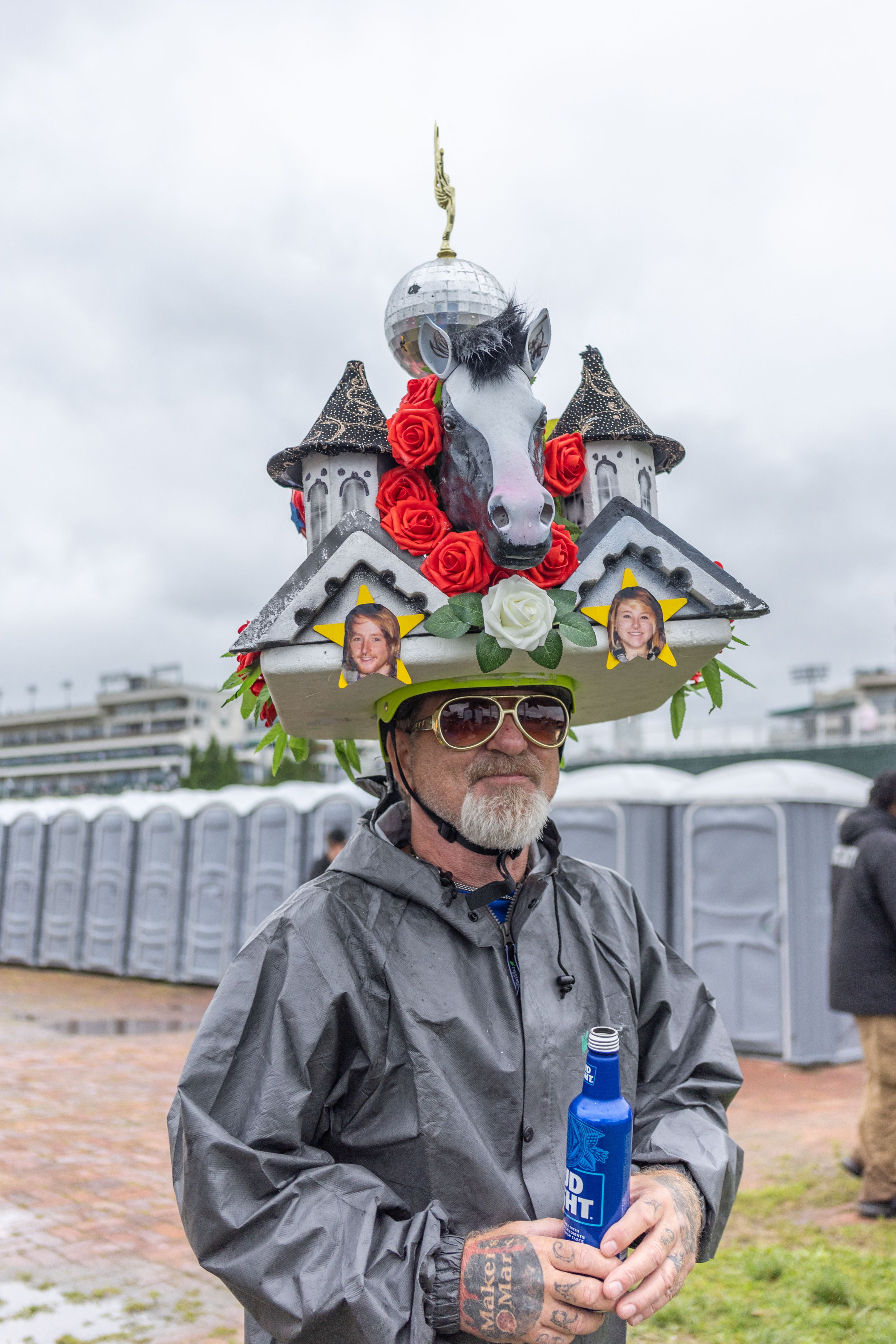 Man in sunglasses wears hat with cathedral, horse and red roses on it