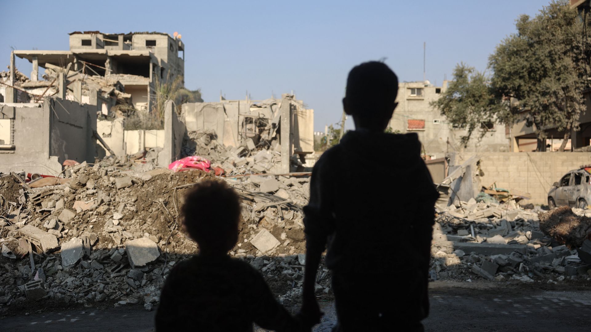Children stare at the destruction following an Israeli strike in the Nuseirat refugee camp in the central Gaza Strip on November 7,