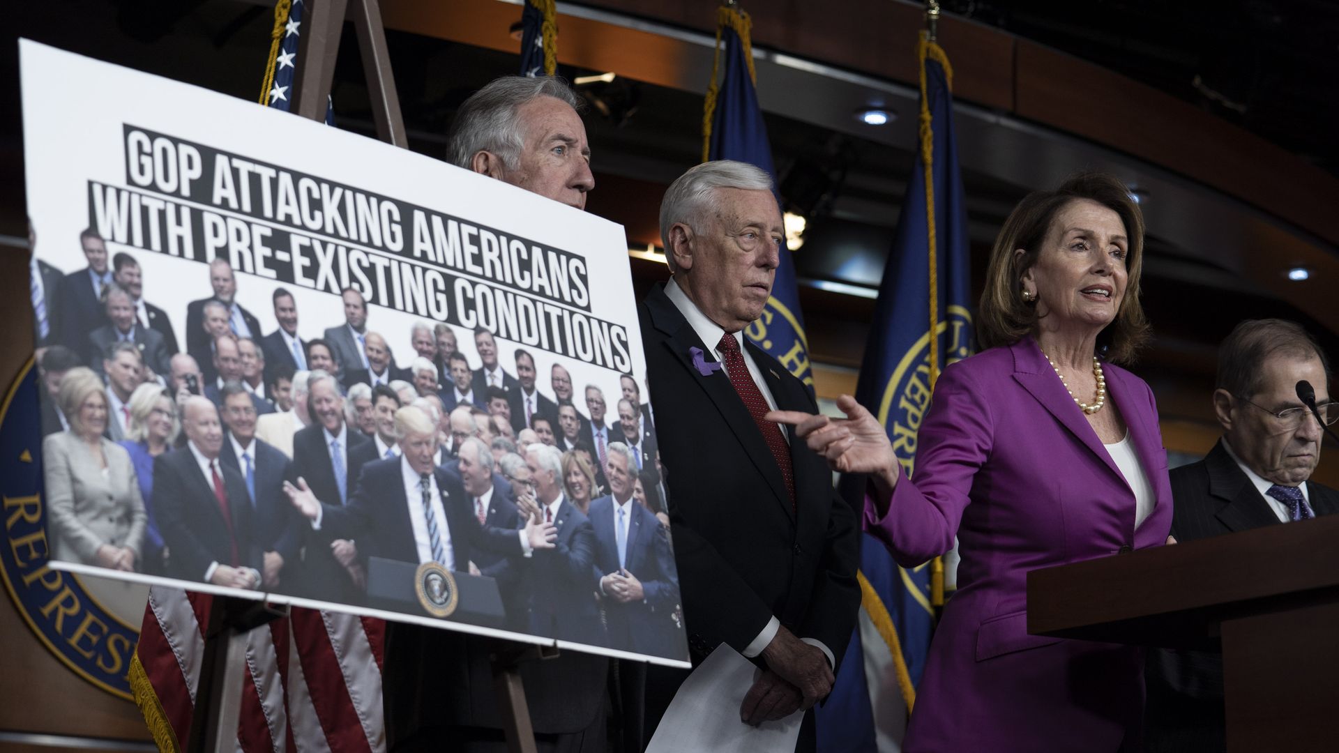 Nancy Pelosi points to a poster about the GOP attacking pre-existing conditions