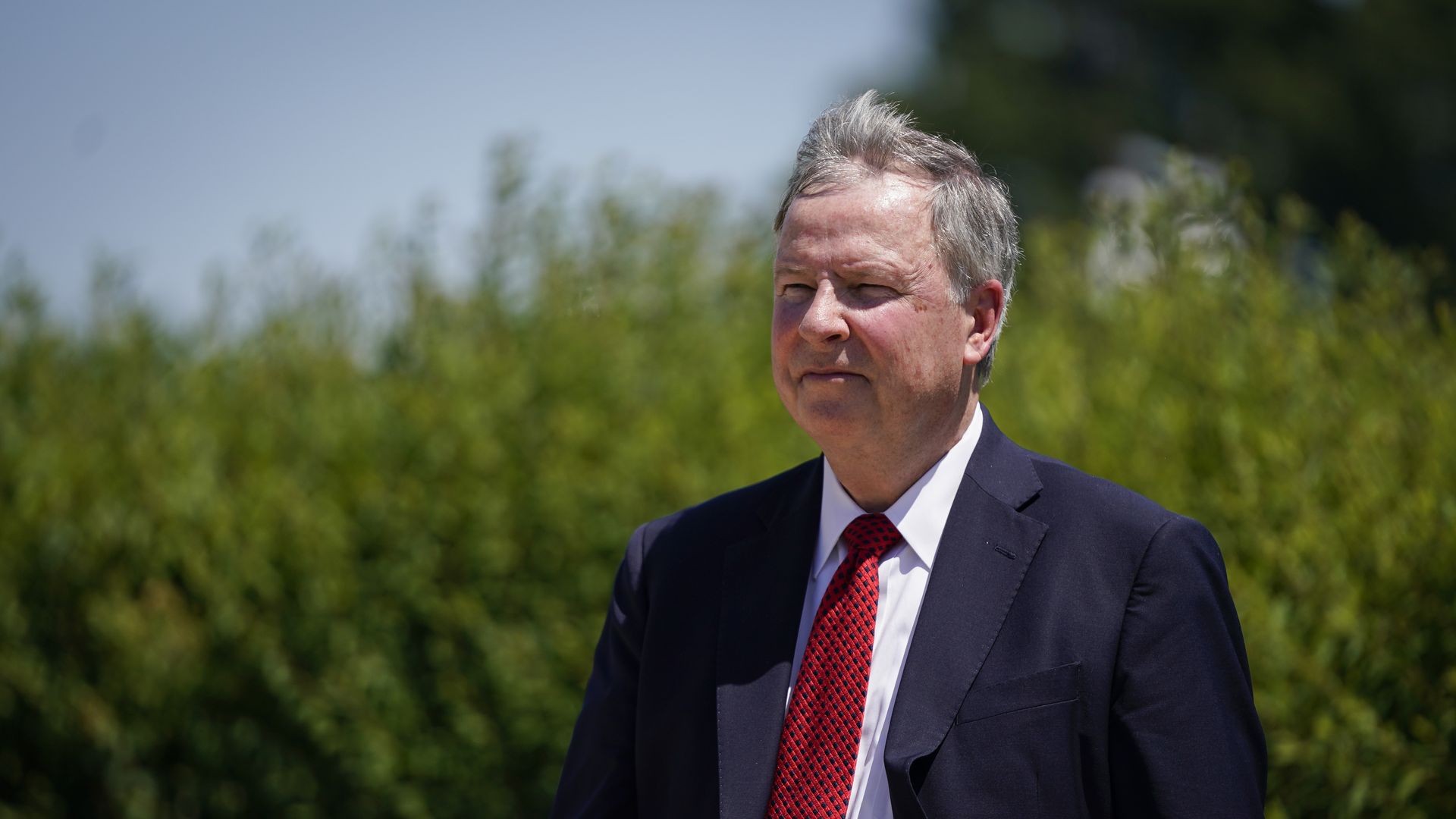 Photo of Doug Lamborn in a suit standing outdoors with grass in the background