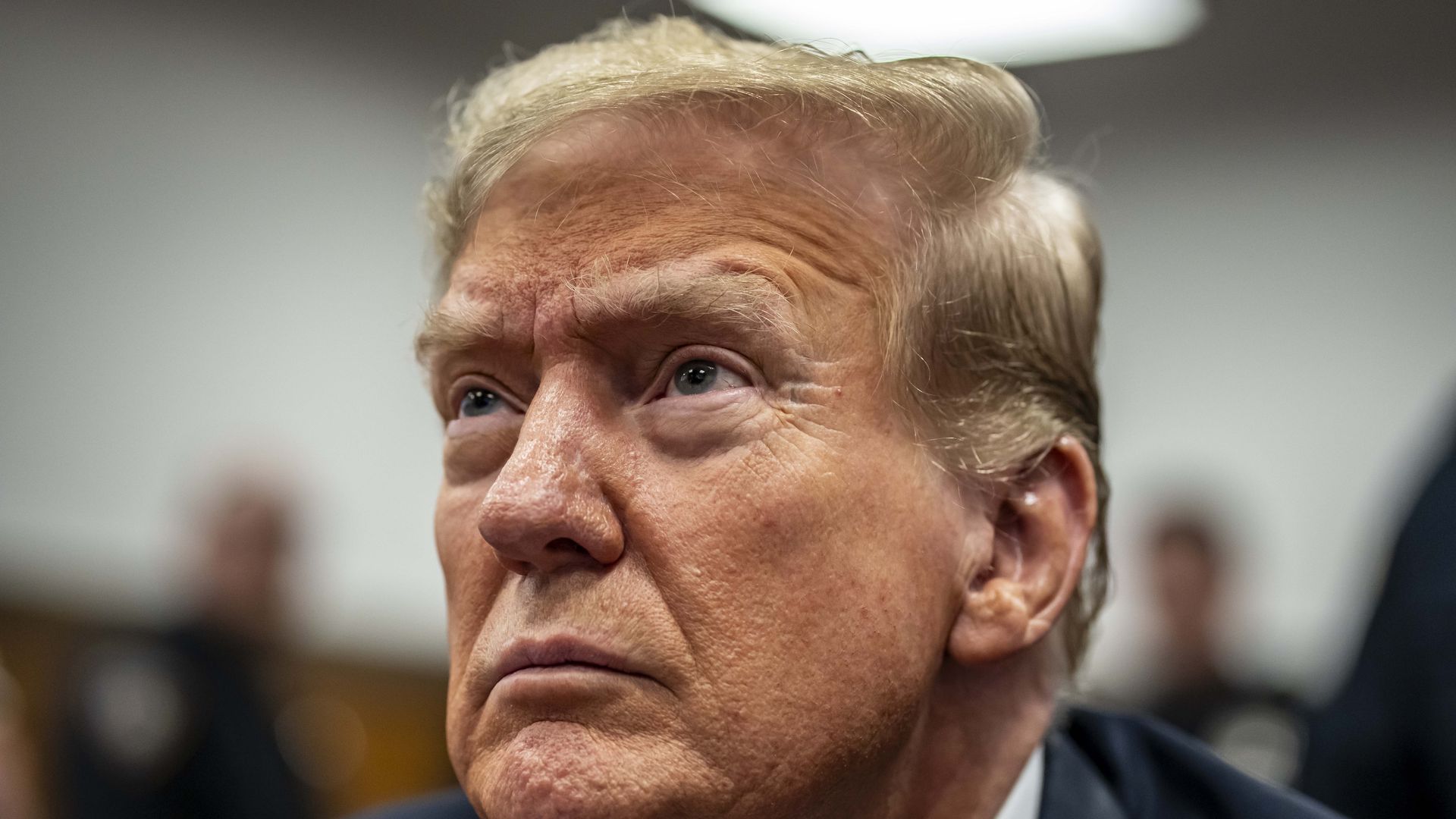 Former U.S. President Donald Trump sits in the courtroom for his trial for allegedly covering up hu