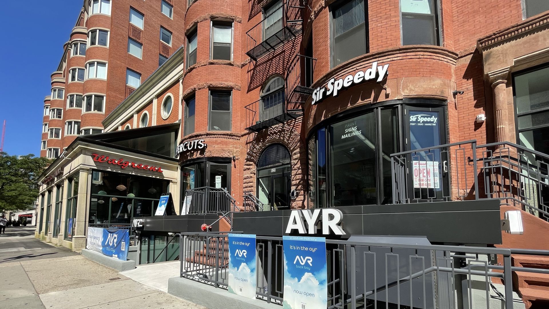The view of Ayr Wellness dispensary from outside on Boylston Street. The word "Ayr" appears in white text over a black-painted storefront