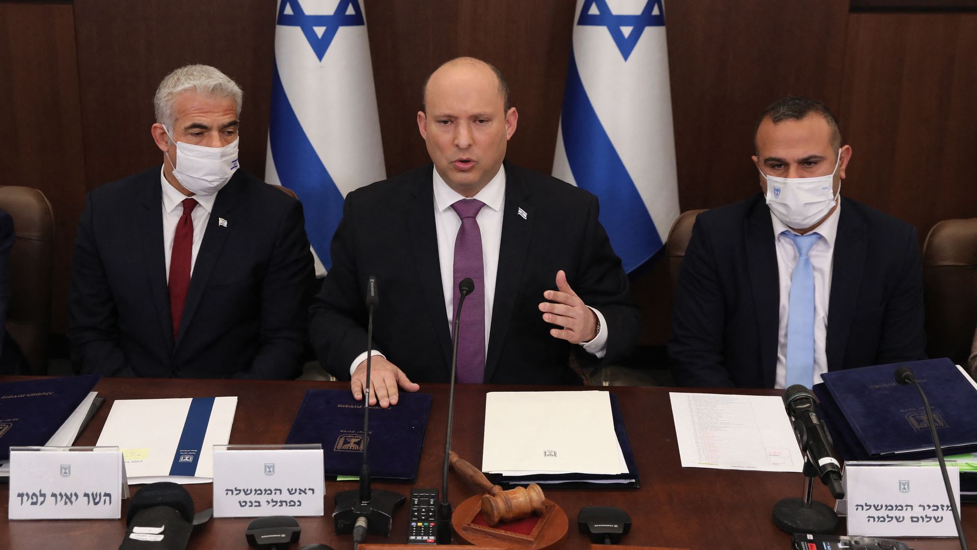 Israeli Prime Minister Naftali Bennett (C), Foreign Minister Yair Lapid (L) and Government Secretary Shalom Shlomo attend a cabinet meeting