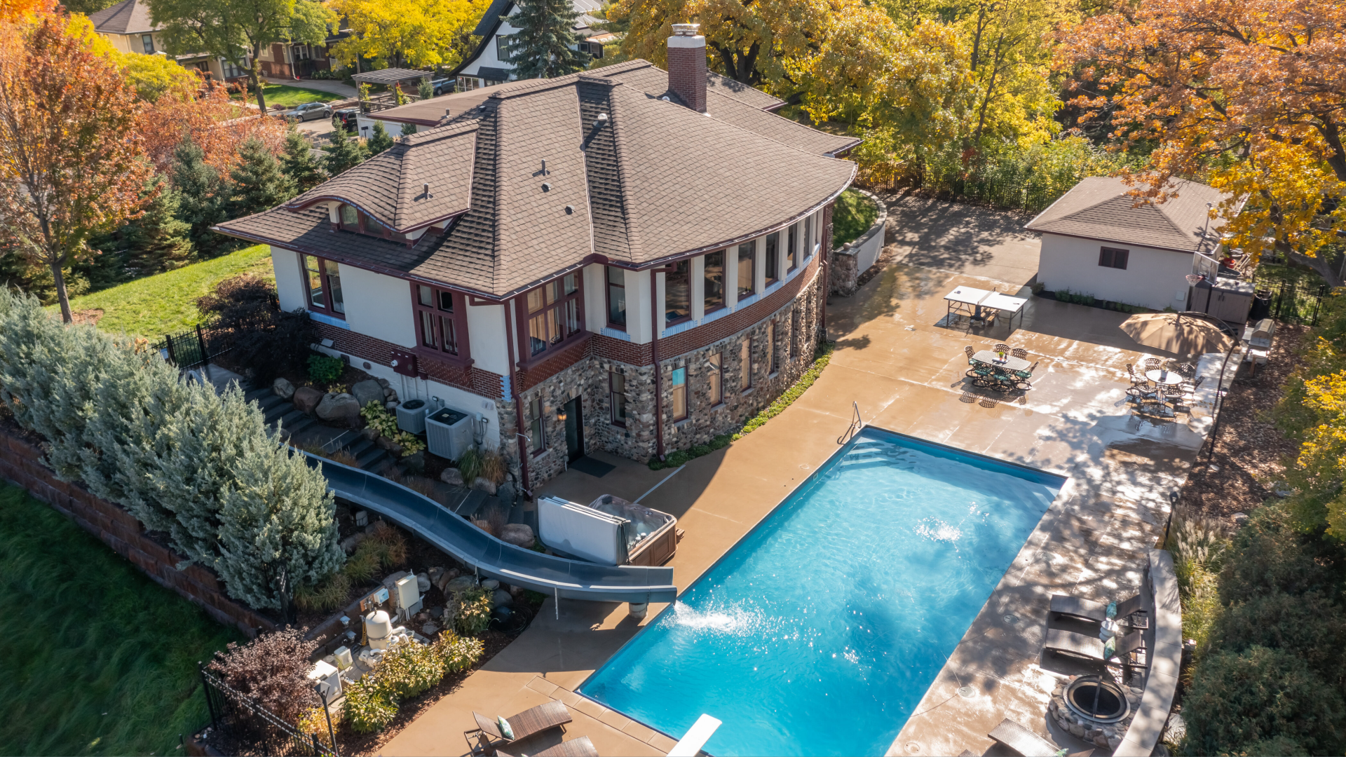 A mansion with a giant pool and waterslide.