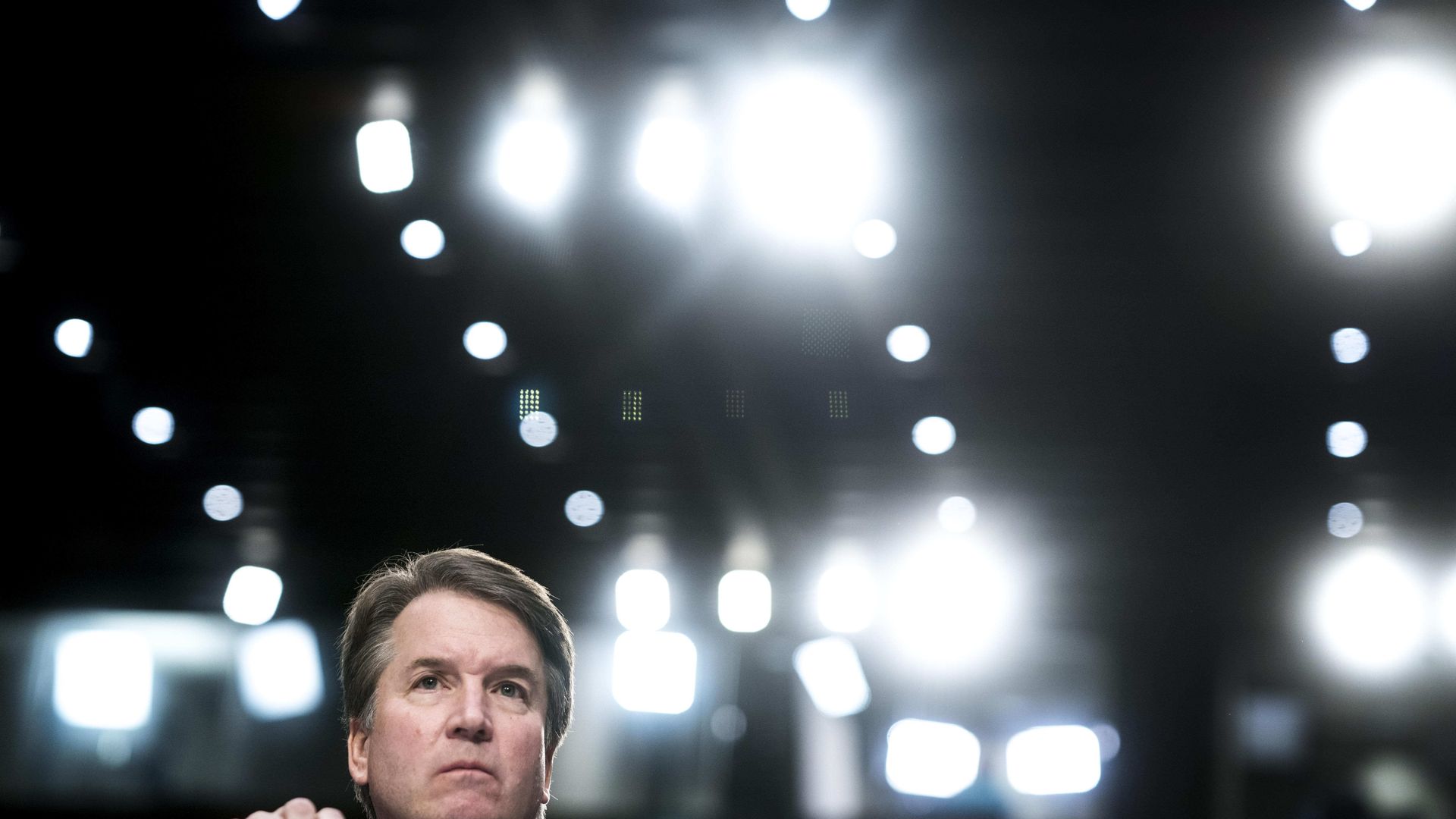 Brett Kavanaugh sitting at table with microphone testifying