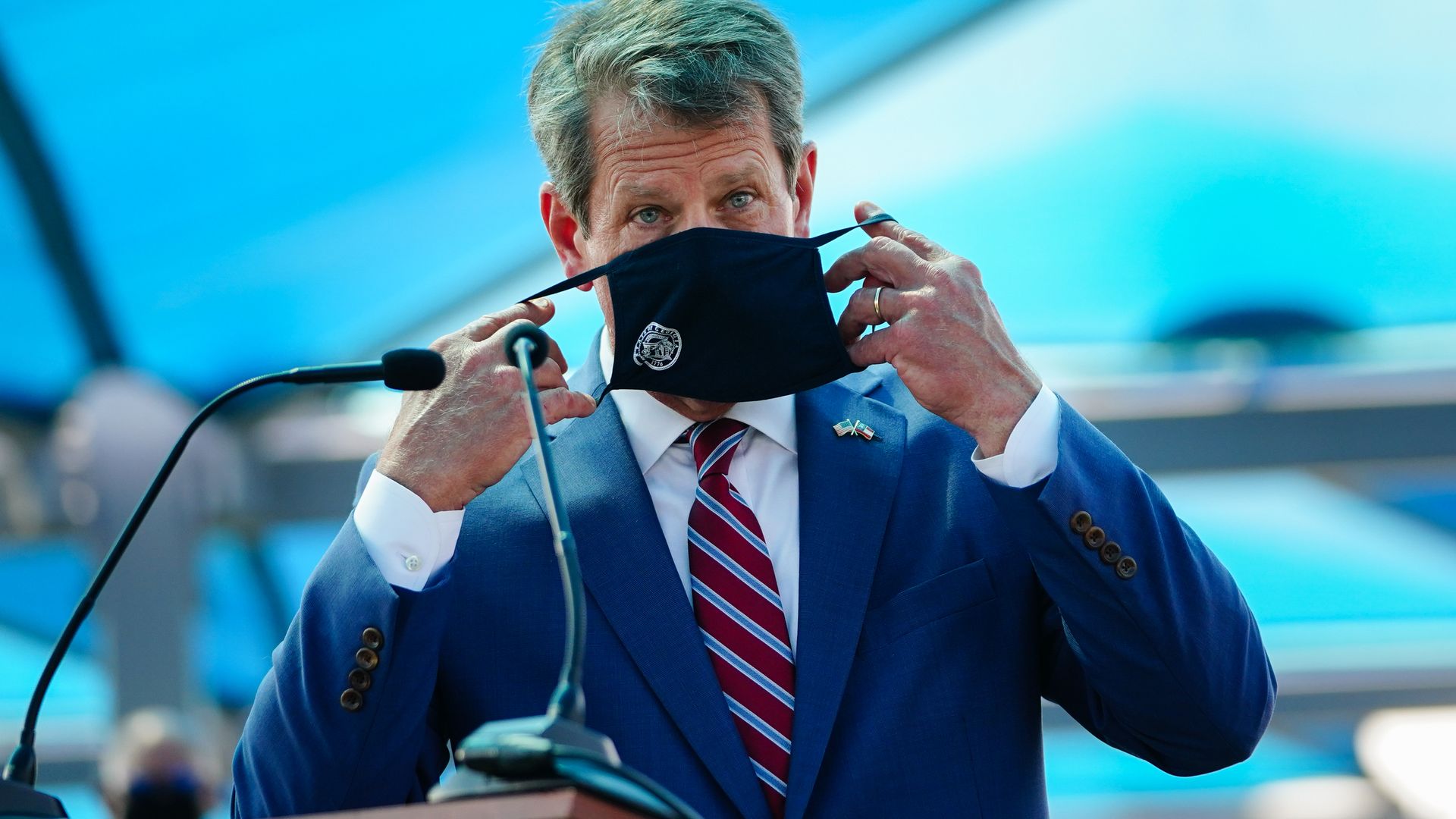 Georgia Governor Brian Kemp puts on a mask after speaking