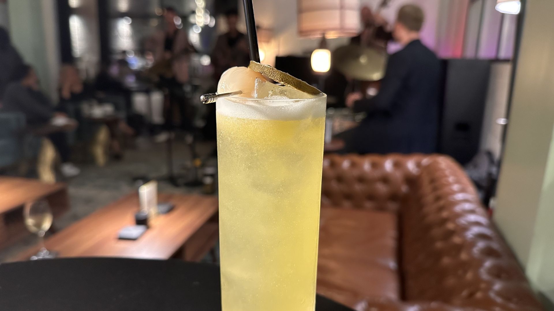 A photo of a high ball cocktail with a jazz band playing in the background 