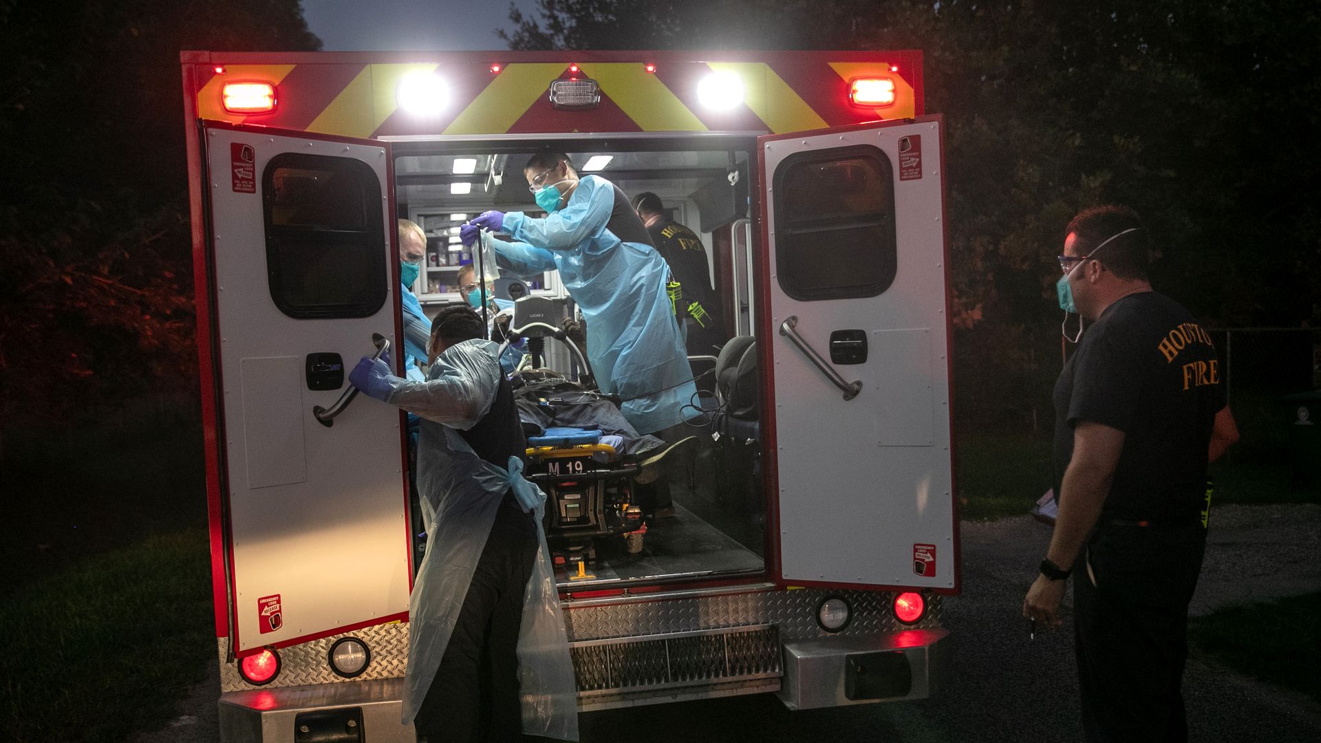 Medics load a heart disease patient into an ambulance.